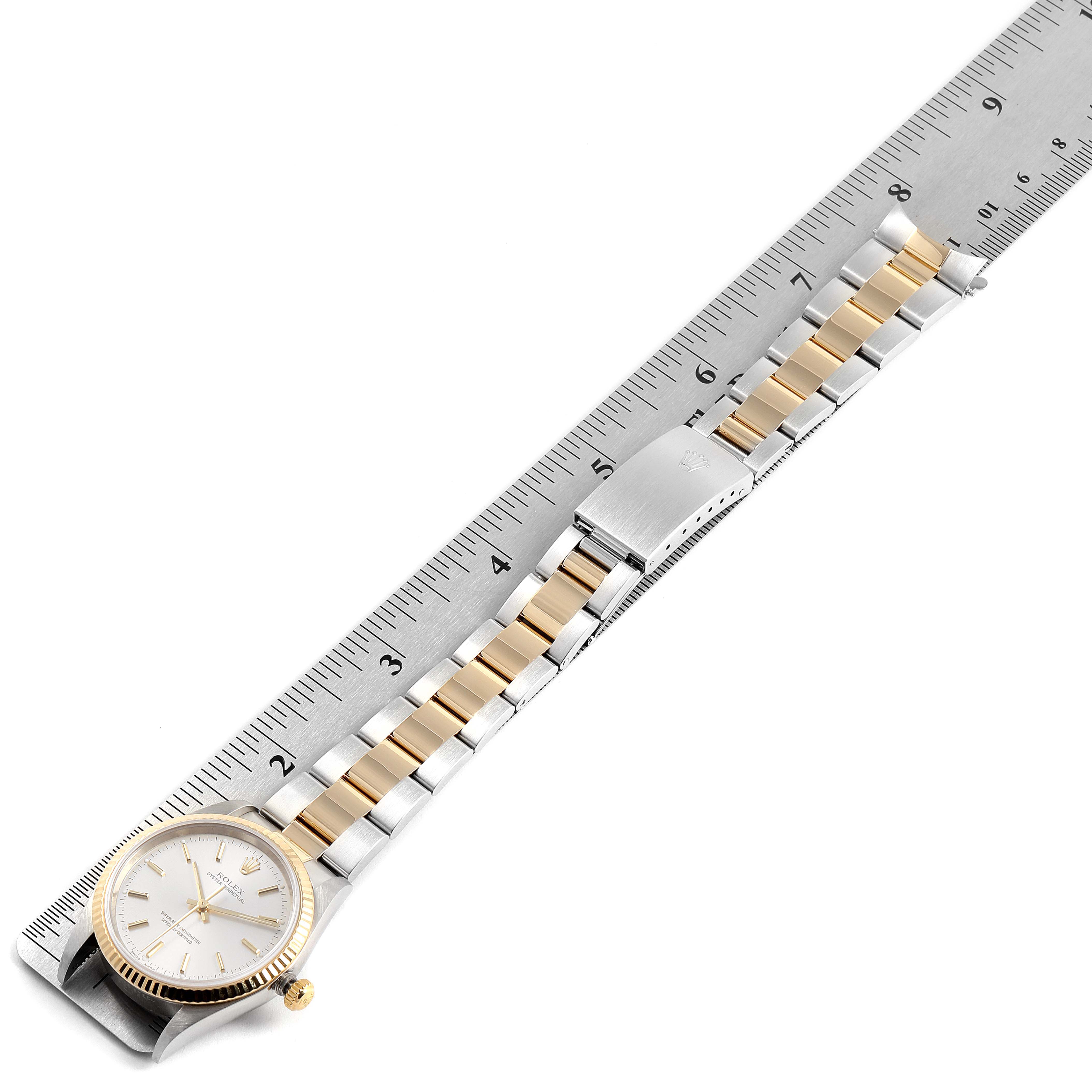 The image shows a Rolex Oyster Perpetual 14233 Men's Steel and Gold (two tone) Silver Dial 14233 Men's Steel and Gold (two tone) Silver Dial watch laid flat, with a ruler measuring the length of its gold and silver band.