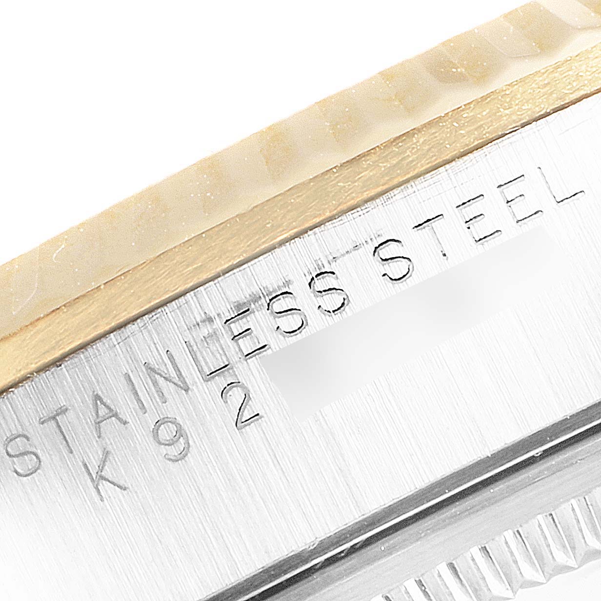 This close-up image shows the side of the casing of a Rolex Oyster Perpetual 14233 Men's Steel and Gold (two tone) Silver Dial 14233 Men's Steel and Gold (two tone) Silver Dial watch, highlighting the "STAINLESS STEEL" engraving.