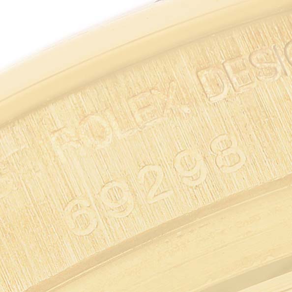 The image shows a close-up of the Rolex Pearlmaster 69298 Women's Yellow Gold White Dial's engraved inner bezel with part of the model number.