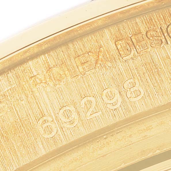 The image shows an angled close-up of the engraved inner part of the Rolex Pearlmaster 69298 Women's Yellow Gold White Dial 69298 Women's Yellow Gold White Dial watch bezel.