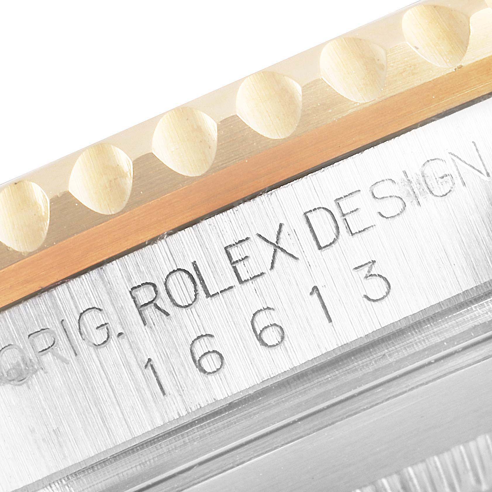 This close-up image of a Rolex Submariner 16613 Men's Steel and Gold (two tone) Black Dial 16613 Men's Steel and Gold (two tone) Black Dial shows the edge of the bezel and the engraved model number on the case.