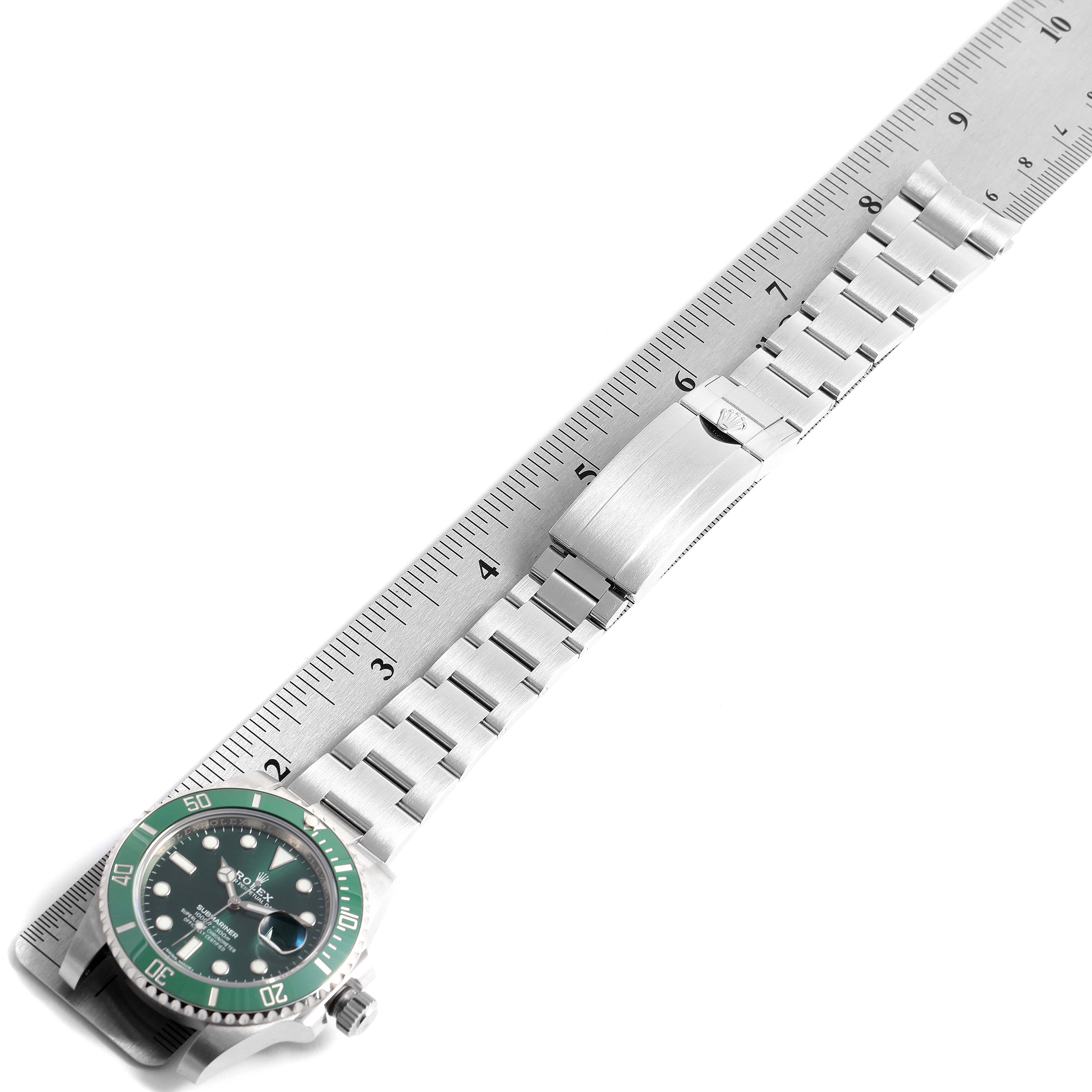 The image shows an overhead view of a Rolex Submariner 116610LV Men's Stainless Steel Green Dial 116610LV Men's Stainless Steel Green Dial watch laid next to a ruler, highlighting the face and the full bracelet.