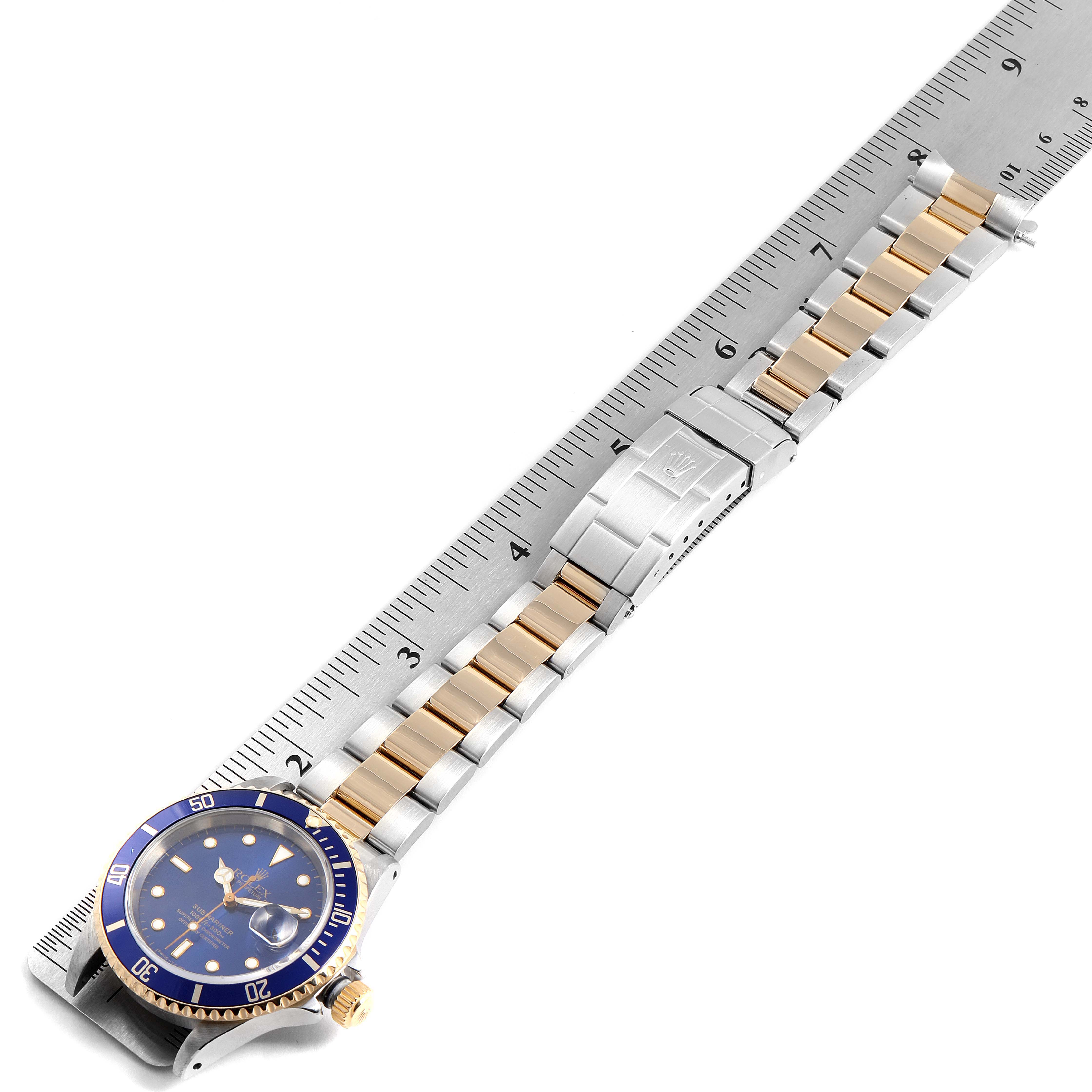 This image shows a Rolex Submariner 16613 Men's Steel and Gold (two tone) Blue Dial 16613 Men's Steel and Gold (two tone) Blue Dial watch laid flat, showcasing the dial, bezel, and two-tone metal bracelet measured with a ruler.