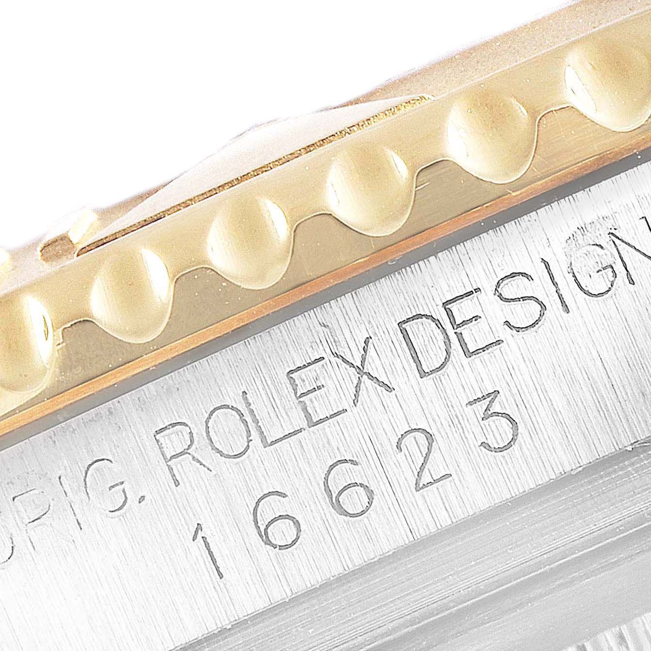 The image shows a close-up angle of the bezel and part of the case back of a Rolex Yacht-Master 16623 Men's Steel and Gold (two tone) Blue Dial 16623 Men's Steel and Gold (two tone) Blue Dial model with visible engraving.