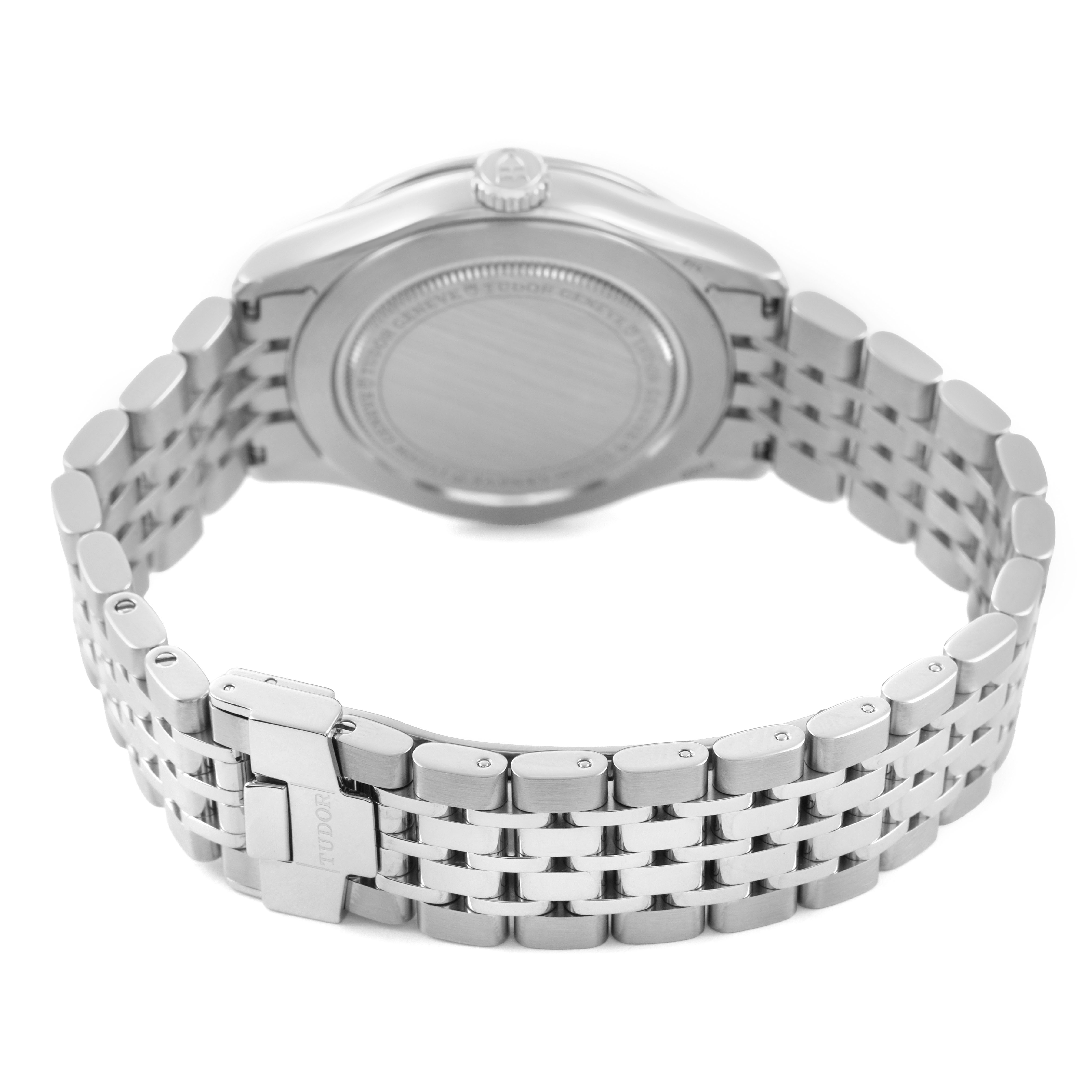 The Tudor 1926 M91450-0001 Men's Stainless Steel Silver Dial model is shown from the back, highlighting the case back, crown, and metal bracelet with clasp.
