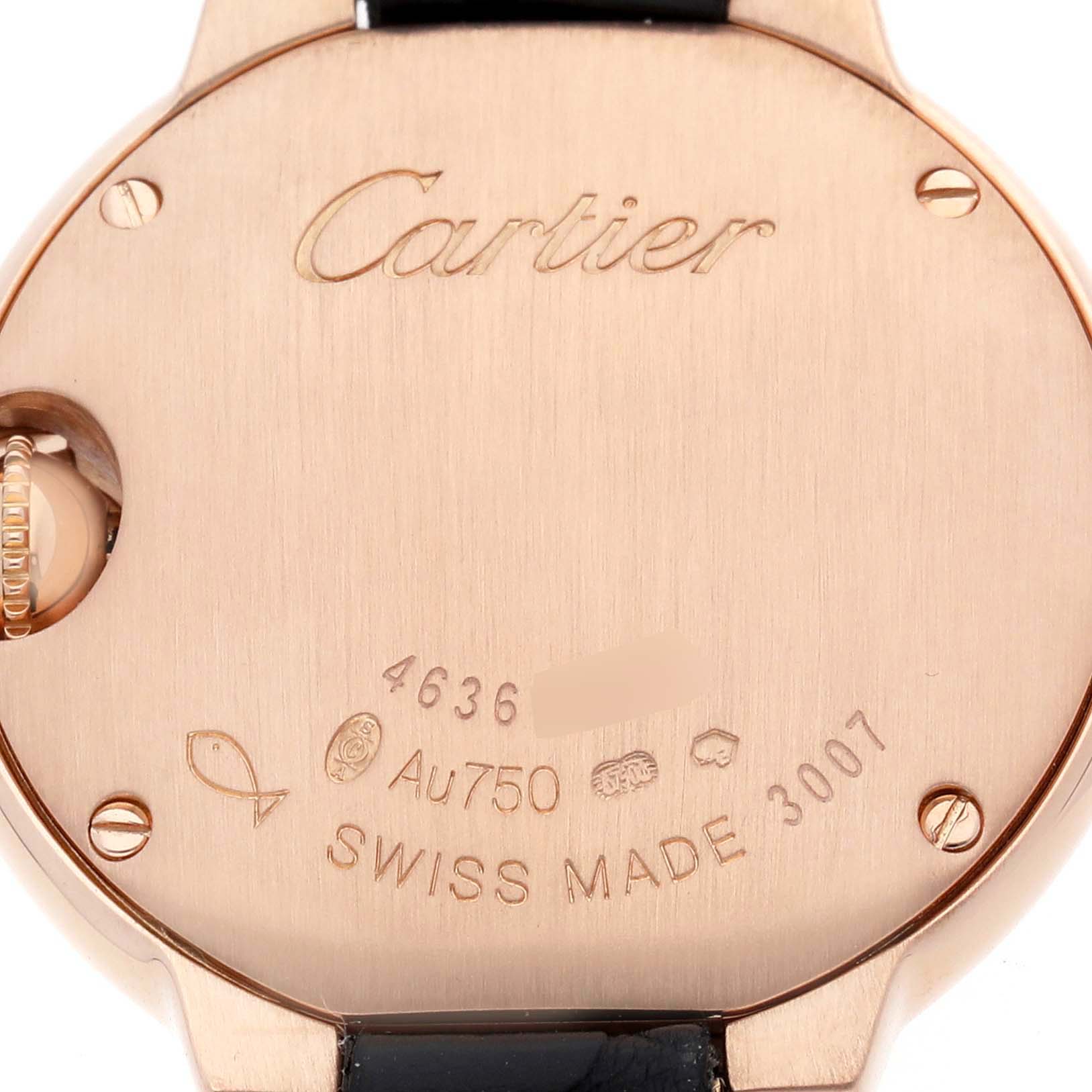 The image shows the back of a Ballon Bleu by Cartier, highlighting engravings and a portion of the strap.
