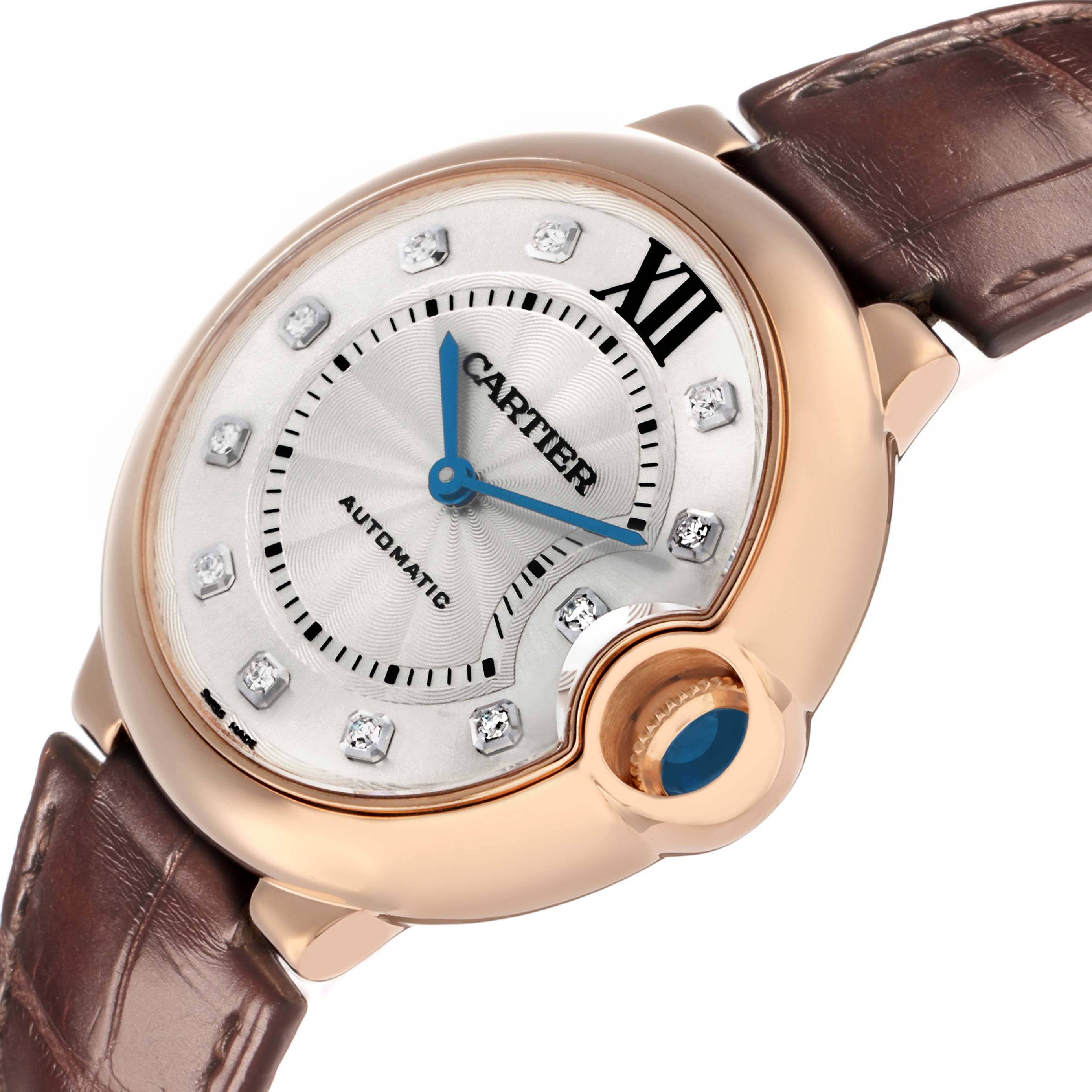 The Cartier Ballon Bleu WE902026 Women
s Rose Gold Silver Dial watch is shown from a top angle, highlighting its silver dial, blue hands, diamond markers, and brown leather strap.