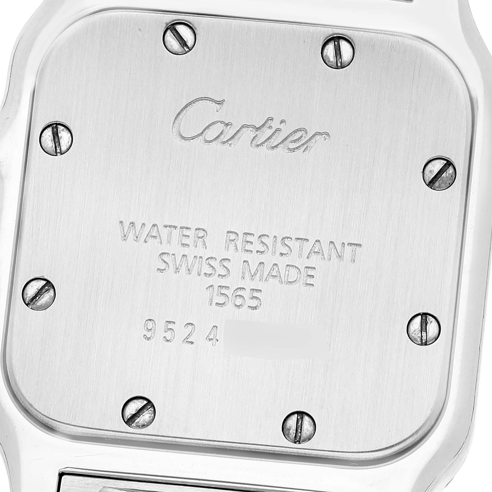 This image shows the back case of a Santos model by Cartier, featuring engraved text and visible screws.
