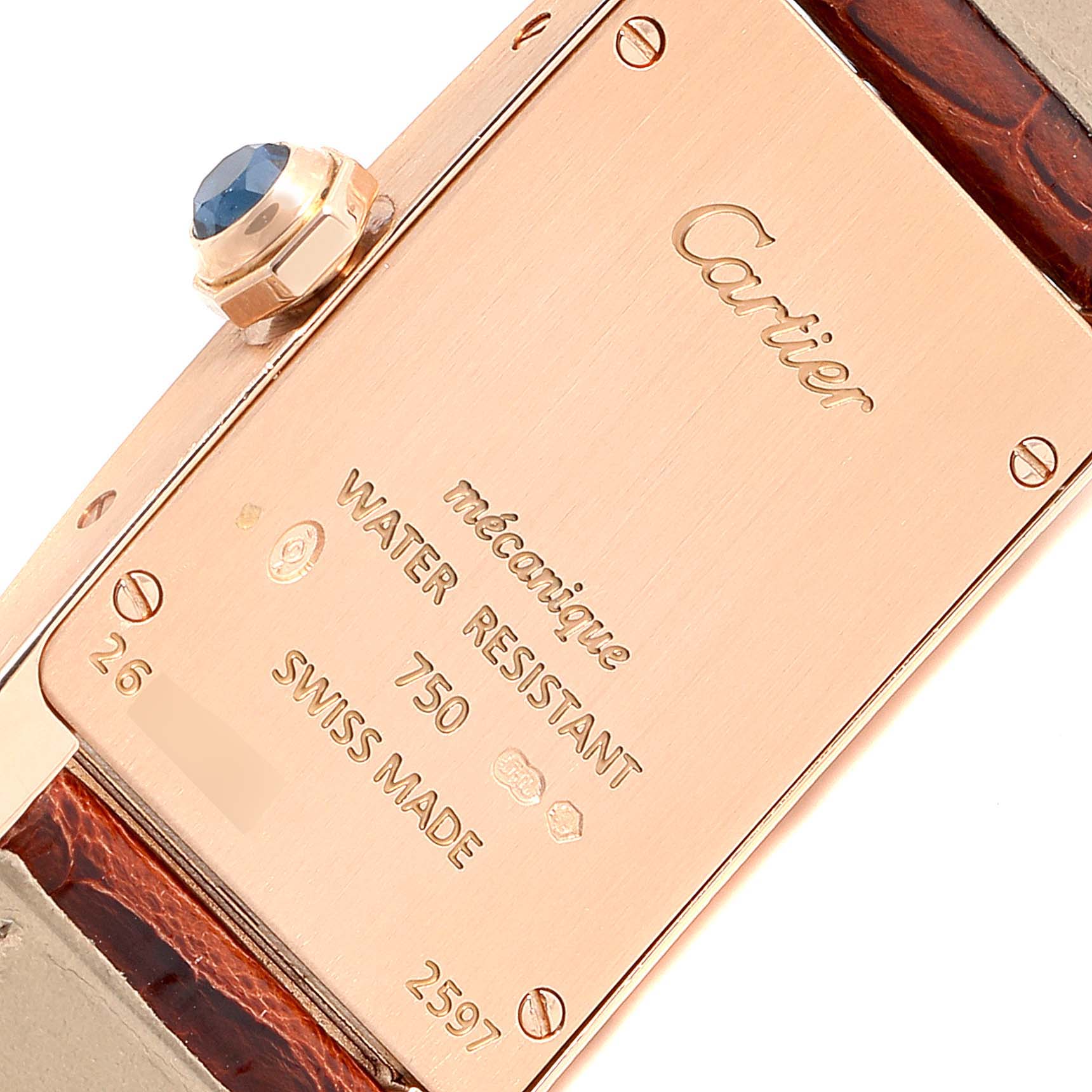 The image shows the back of a Cartier Tank Americaine 2597 Women's Rose Gold Pink Dial 2597 Women's Rose Gold Pink Dial watch, highlighting its inscriptions and crown.