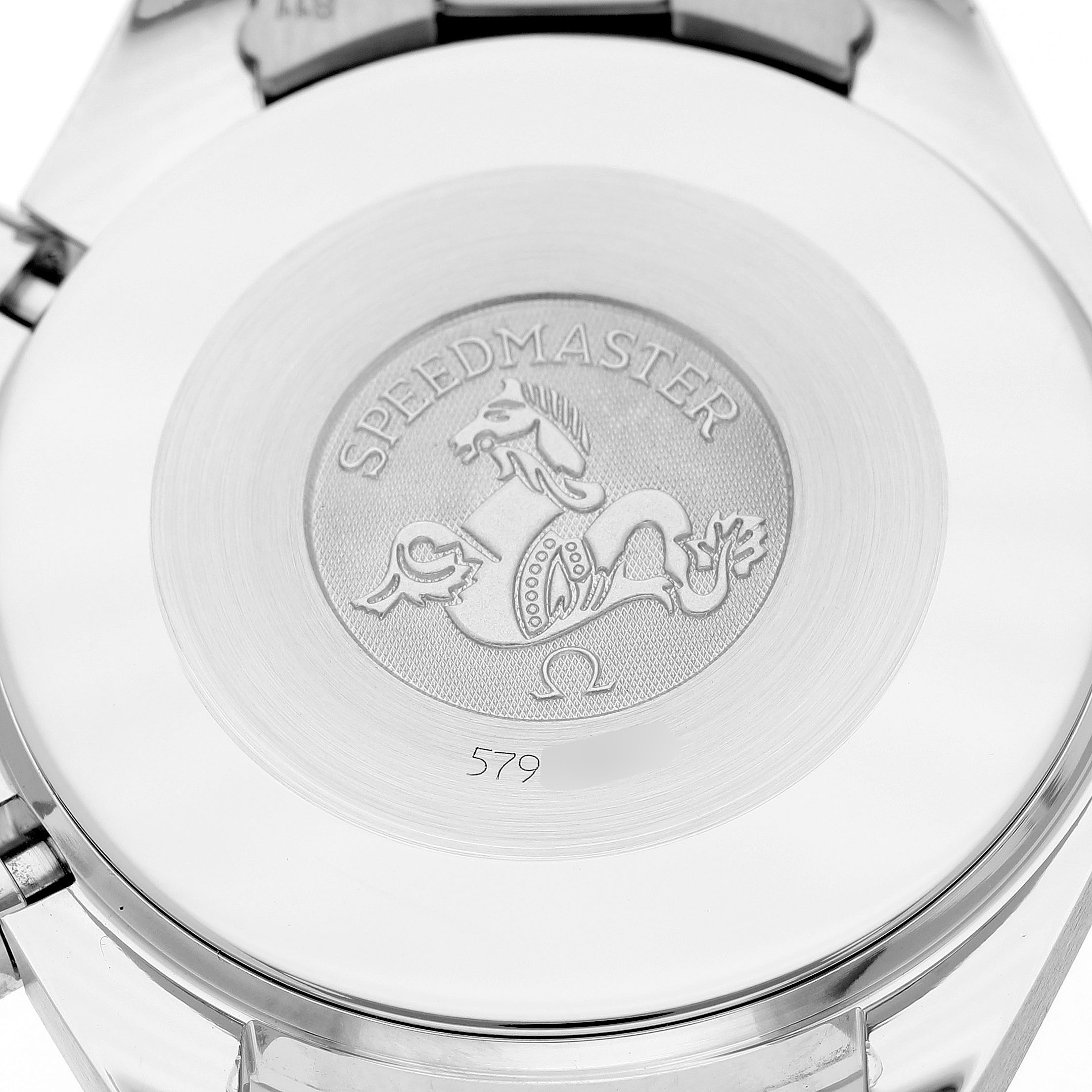 The image shows the case back of an Omega Speedmaster 3502.71.00 Men's Stainless Steel Mother of Pearl Dial watch featuring an engraved emblem.