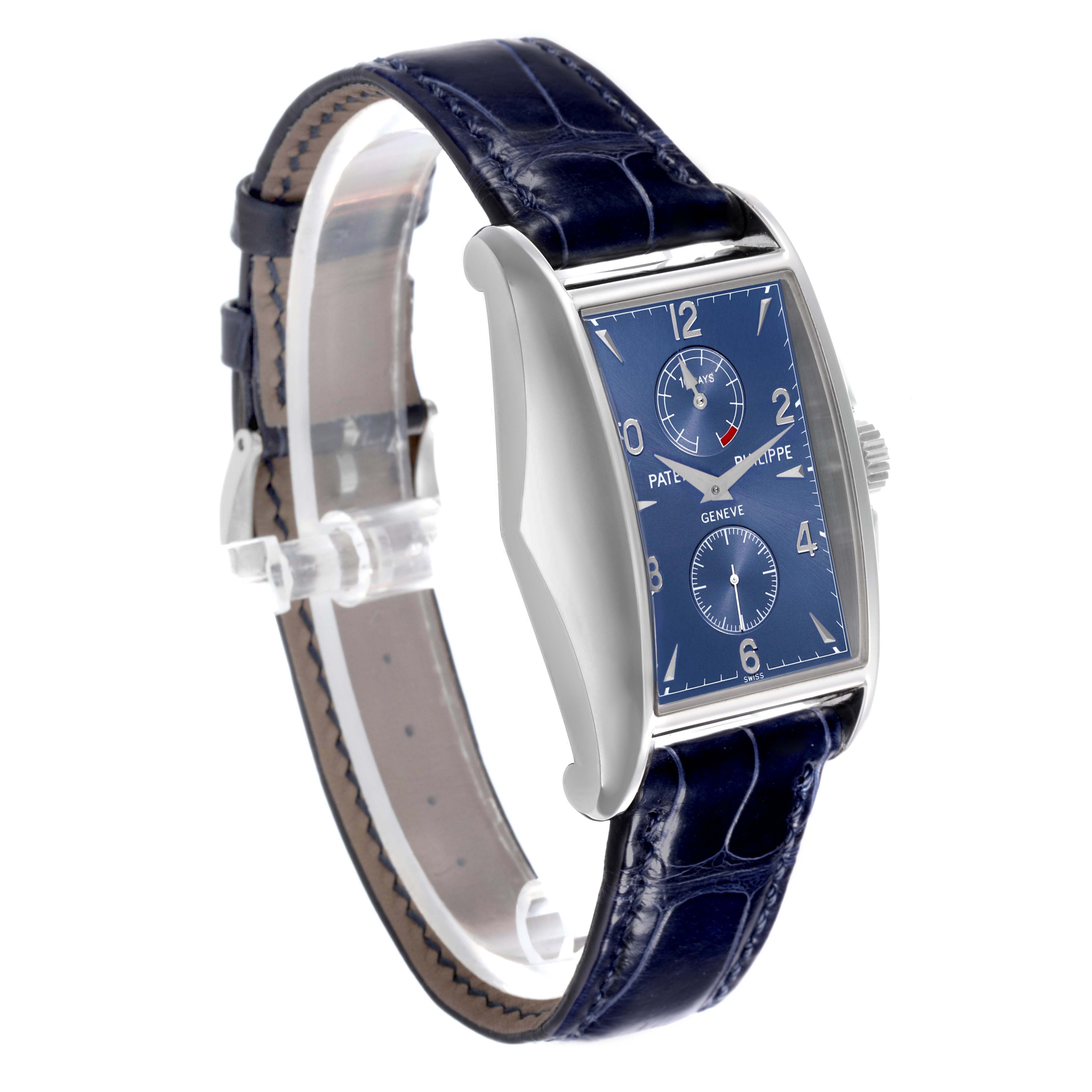 The Patek Philippe Gondolo 5100G - 001 Men's White Gold Blue Dial watch is shown at a side angle, displaying its blue dial, silver case, and leather strap.