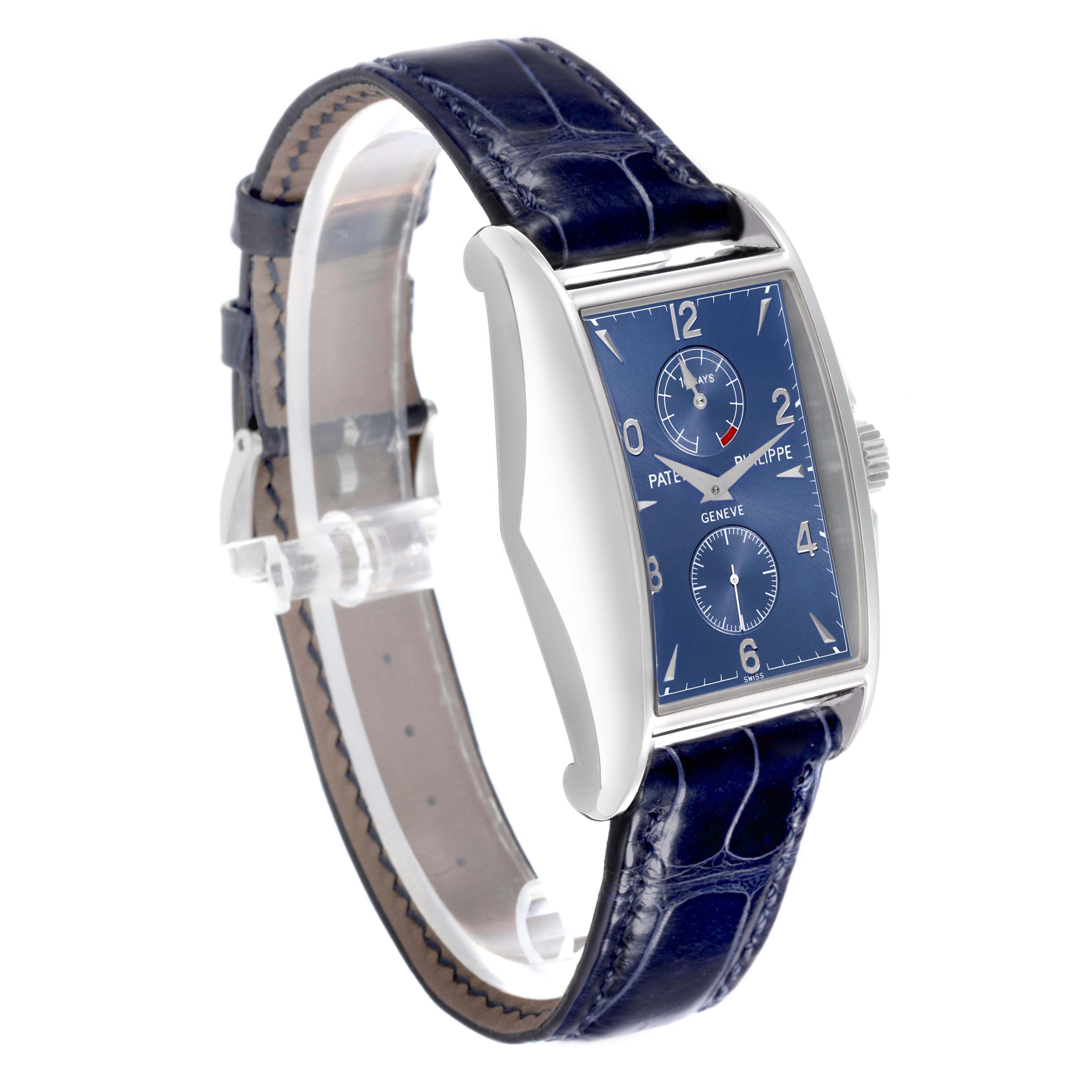 The Patek Philippe Gondolo 5100G - 001 Men's White Gold Blue Dial watch is shown at a three-quarter angle, highlighting its blue dial, side profile, and leather strap.