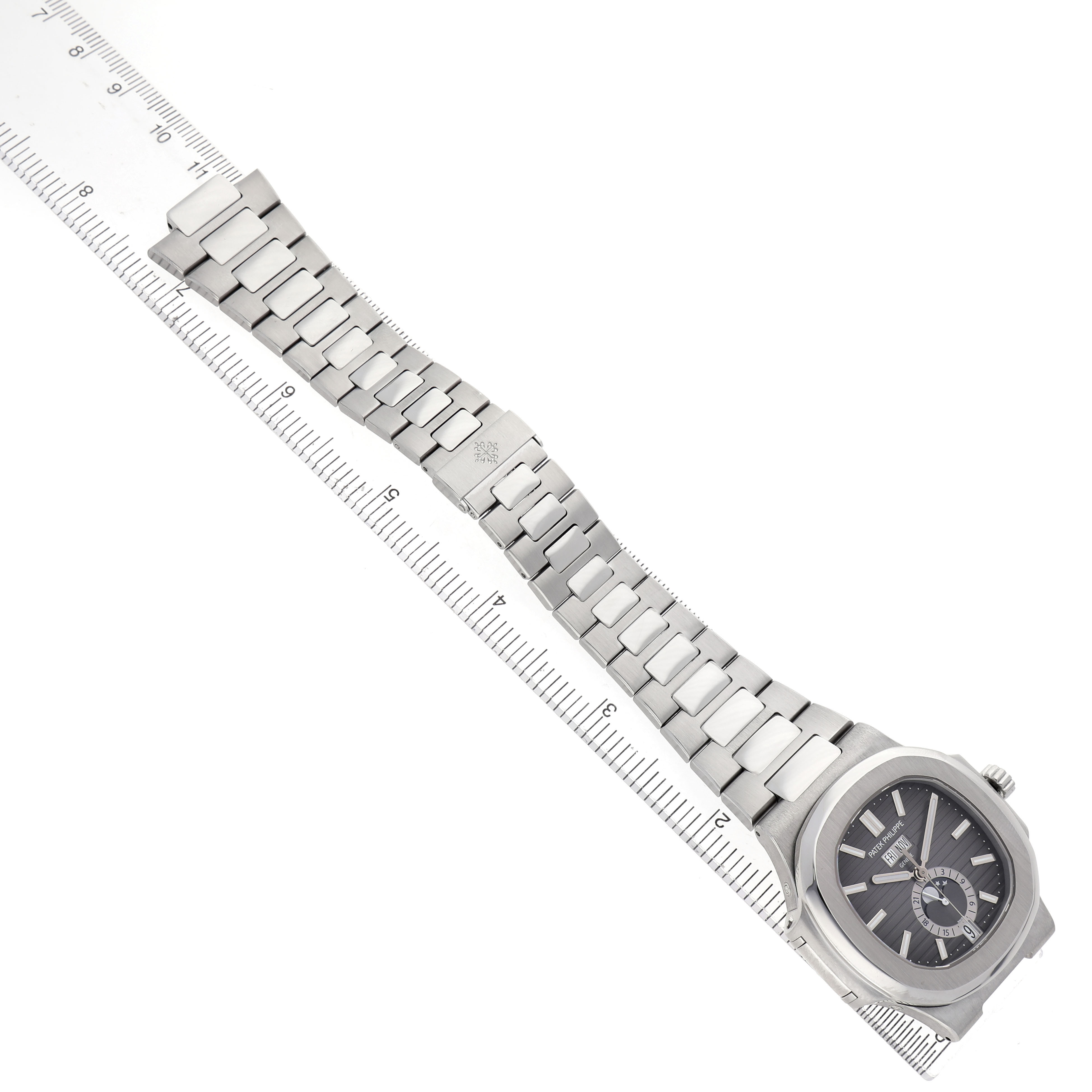 The Patek Philippe Nautilus 5726/1A-001 Men's Stainless Steel Green Dial watch is shown from a top-down angle, highlighting the face, dial, and metal bracelet alongside a ruler.