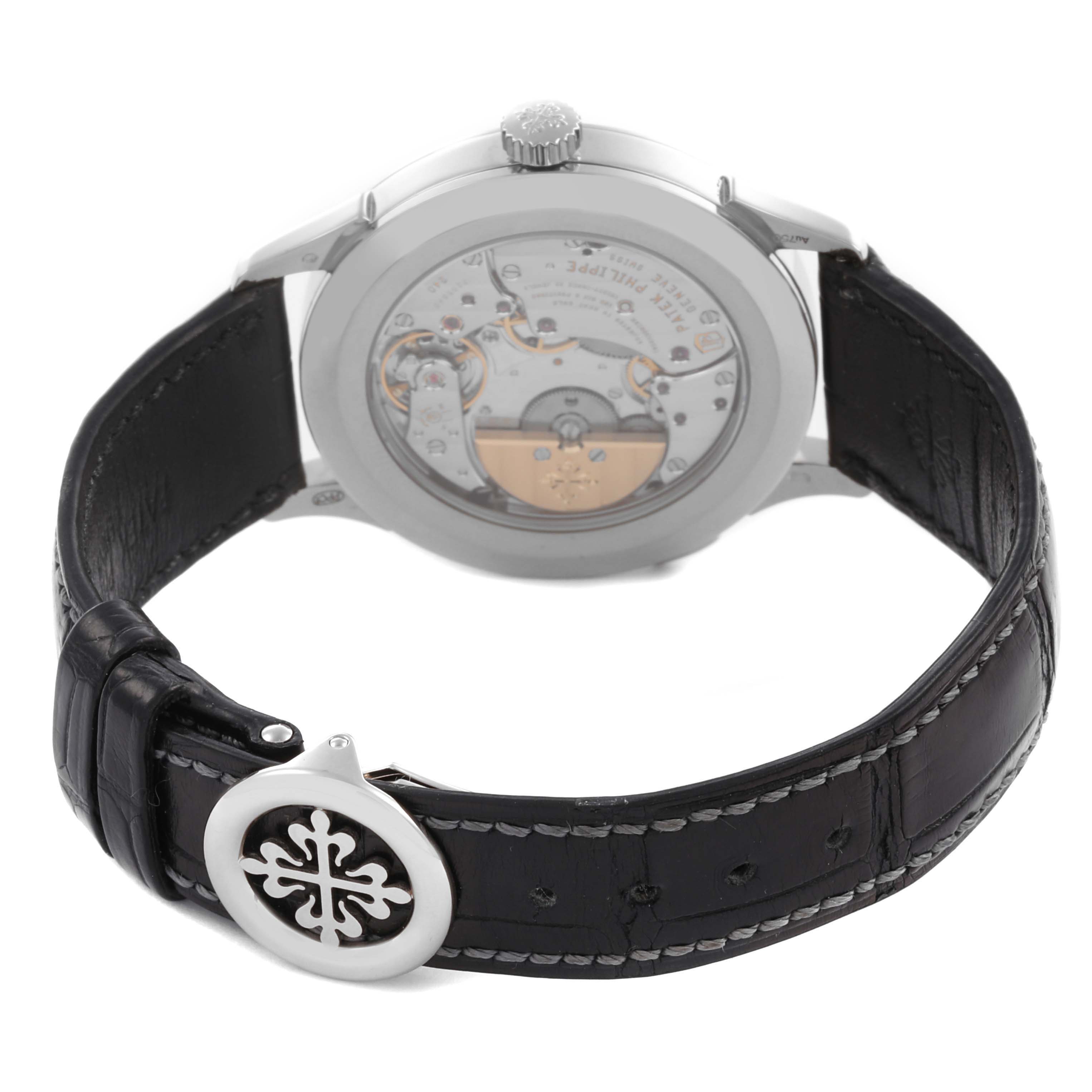 The Patek Philippe Complications 5230G-001 Men's White Gold Grey Dial 5230G-001 Men's White Gold Grey Dial watch is shown from the back, highlighting its movement and leather strap with a distinctive clasp.