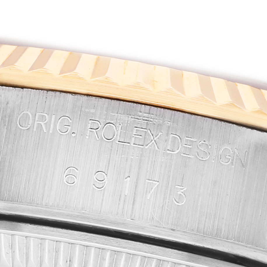 The image shows a close-up of the Rolex Datejust 69173 Women's Steel and Gold (two tone) Blue Dial model's engraved side with a focus on the fluted bezel.