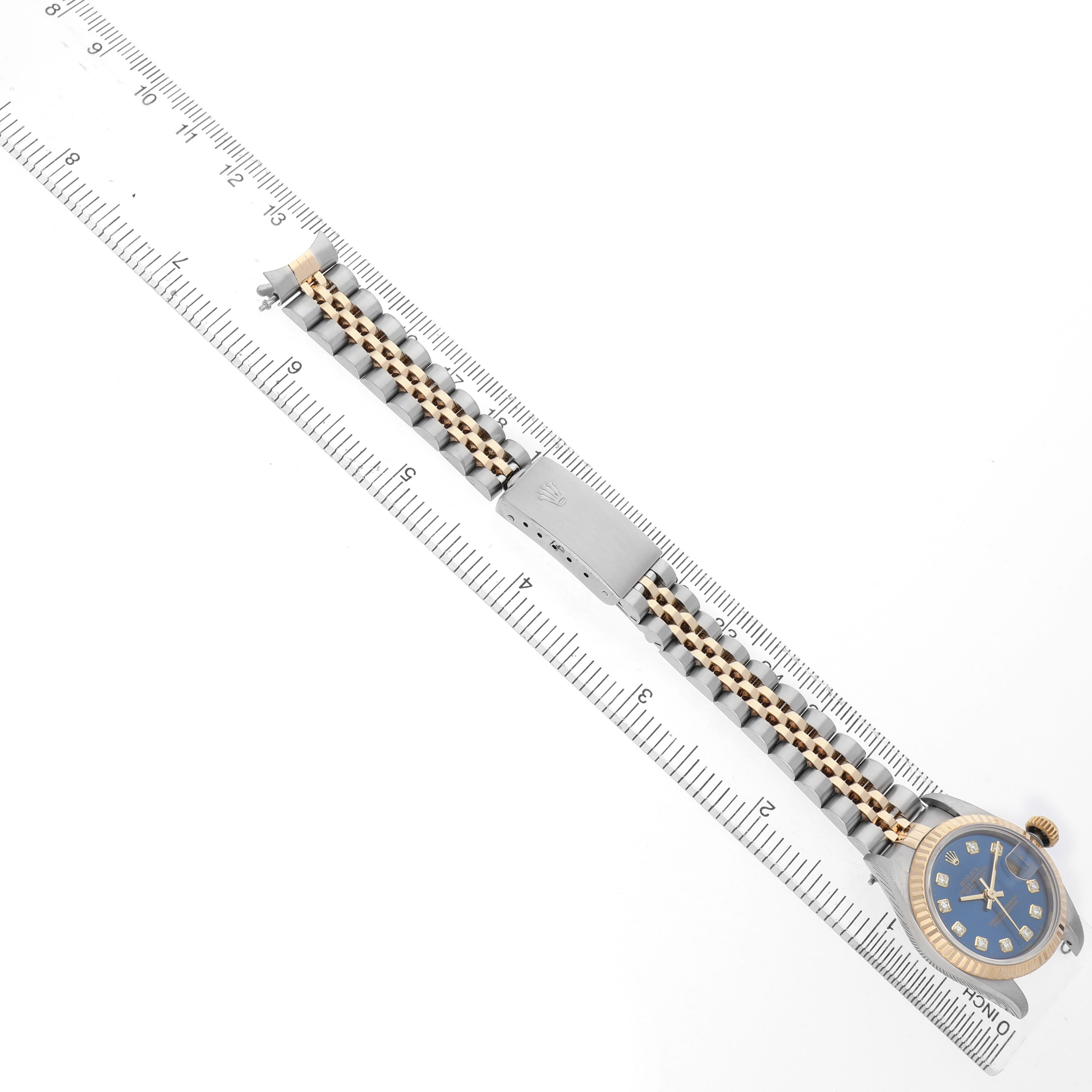 The image shows a Rolex Datejust 69173 Women's Steel and Gold (two tone) Blue Dial watch laid flat with its bracelet extended alongside a ruler for scale.