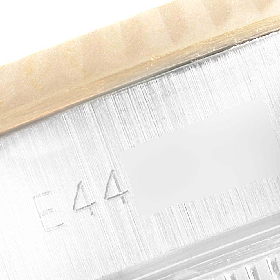 This is a close-up of a serial number engraving on the bezel and case side of a Rolex Datejust 69173 Women's Steel and Gold (two tone) Champagne Dial 69173 Women's Steel and Gold (two tone) Champagne Dial watch.