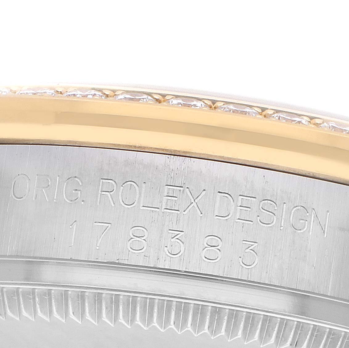 The image shows a close-up of the side of a Rolex Mid-Size 178383 Women
s Steel and Gold (two tone) Silver Dial watch, highlighting the engraved design and the bezel with diamonds.