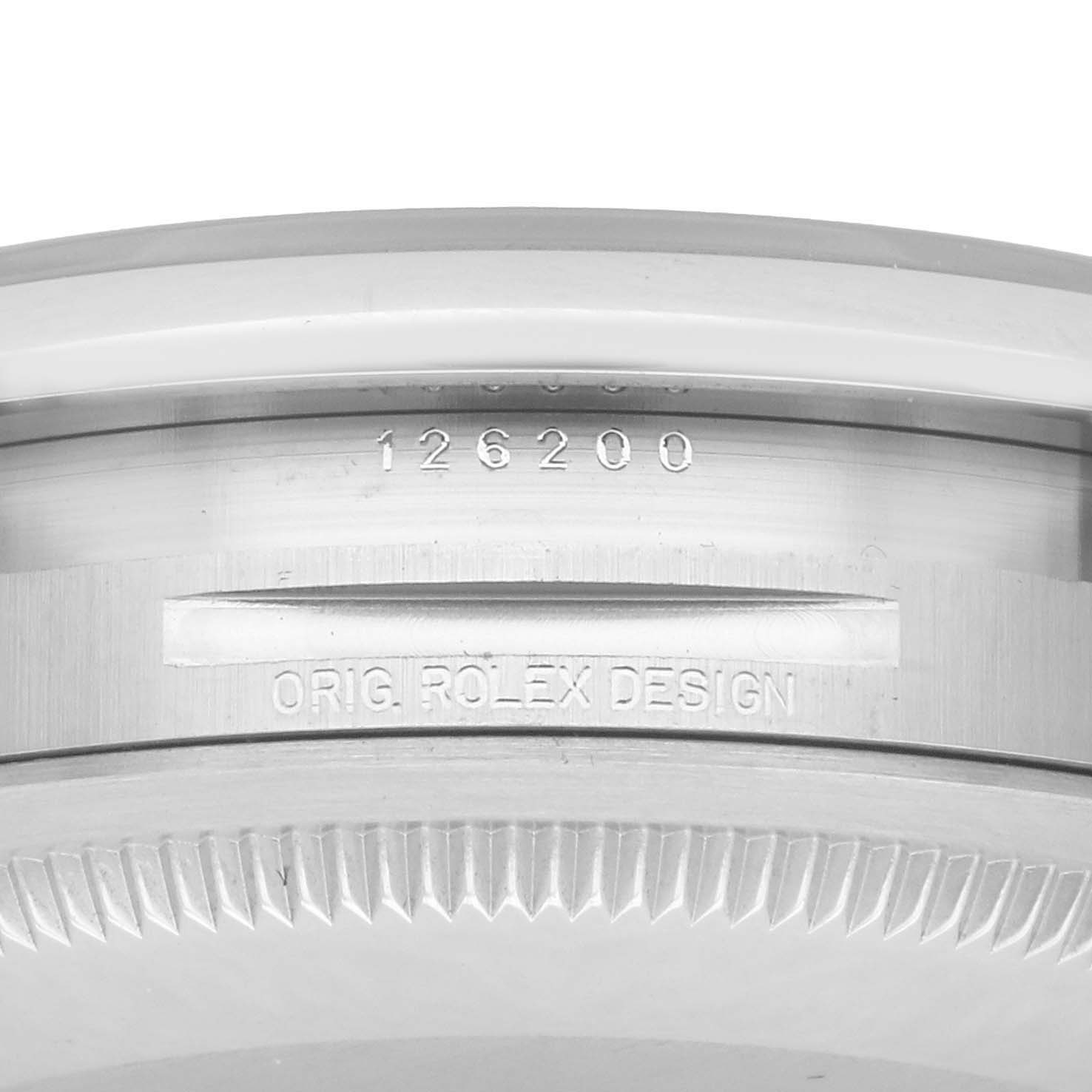 The image shows a close-up of the engraved inner bezel and case of a Rolex Datejust 126200 Men
s Stainless Steel Black Dial, displaying model details.