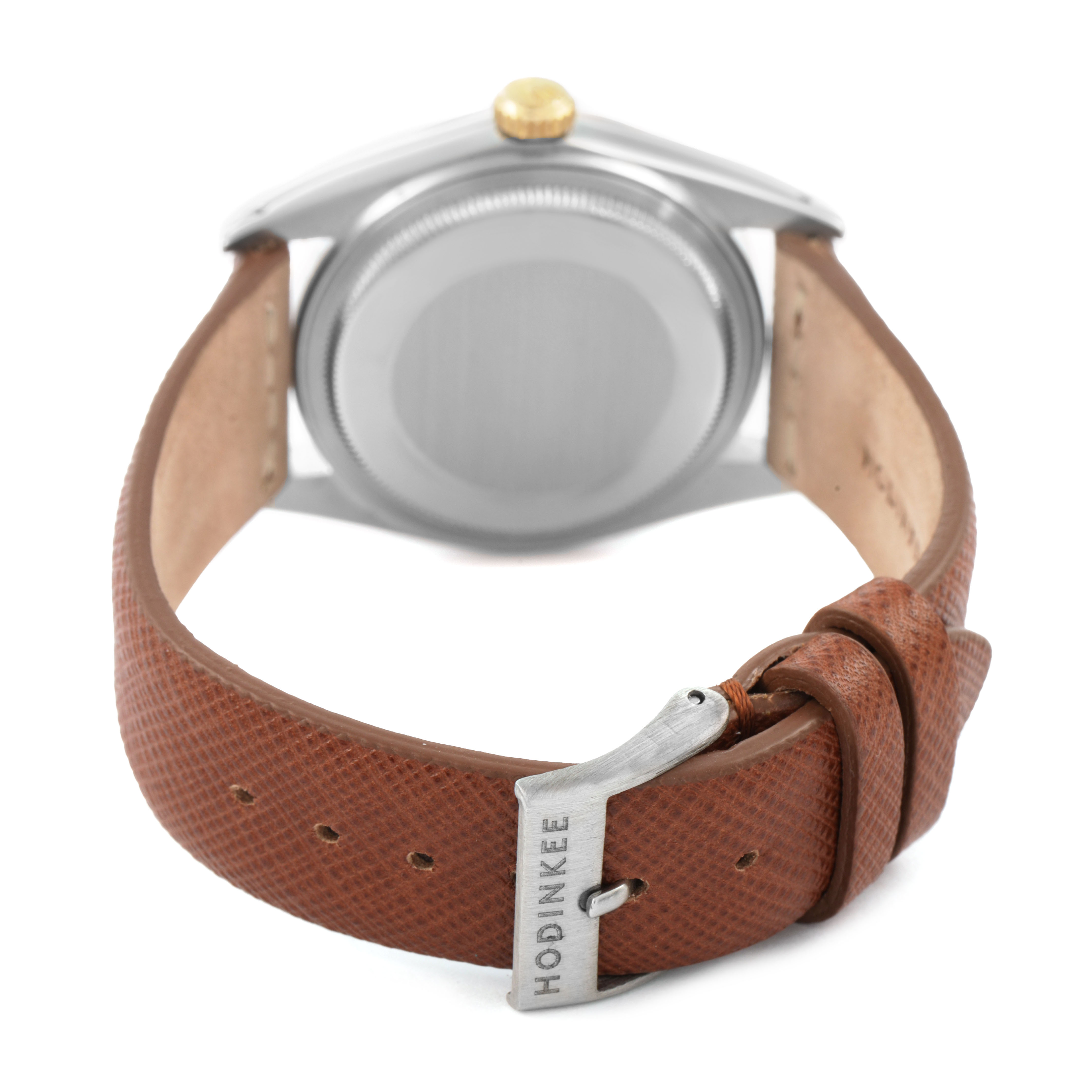 The image shows the back of a Rolex Datejust 16013 Men's Steel and Gold (two tone) Champagne Dial watch with a brown leather strap and a buckle labeled "Hodinkee."