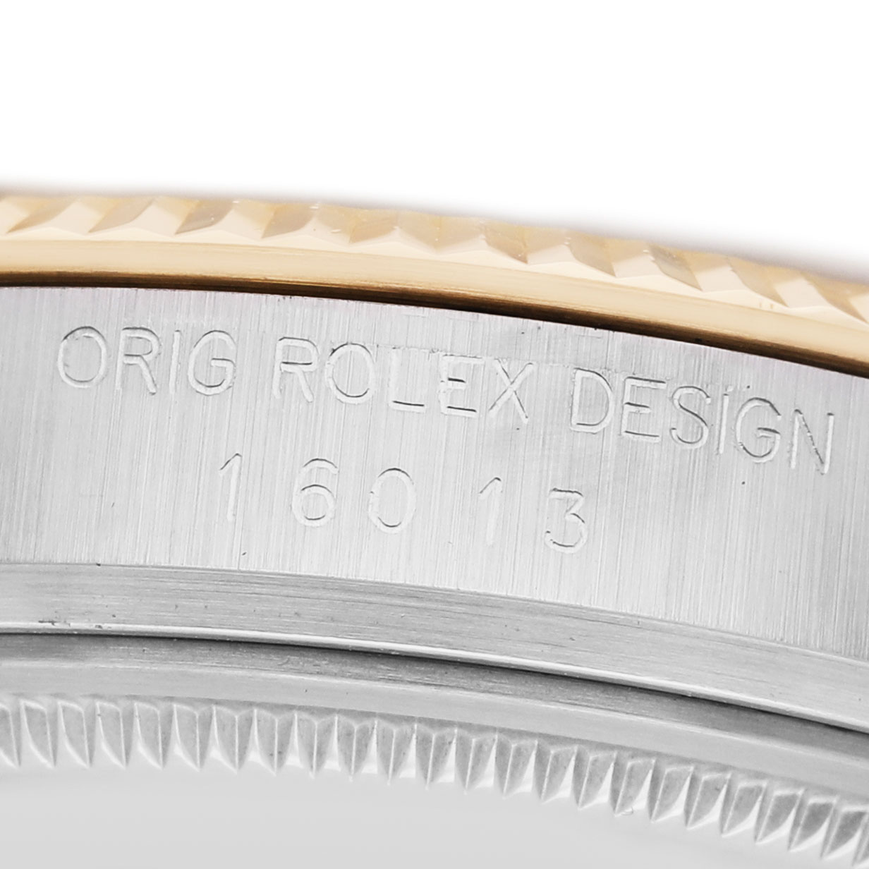 The image shows a close-up of the side of a Rolex Datejust 16013 Men's Steel and Gold (two tone) Champagne Dial, focusing on the fluted bezel and engraved design markings.