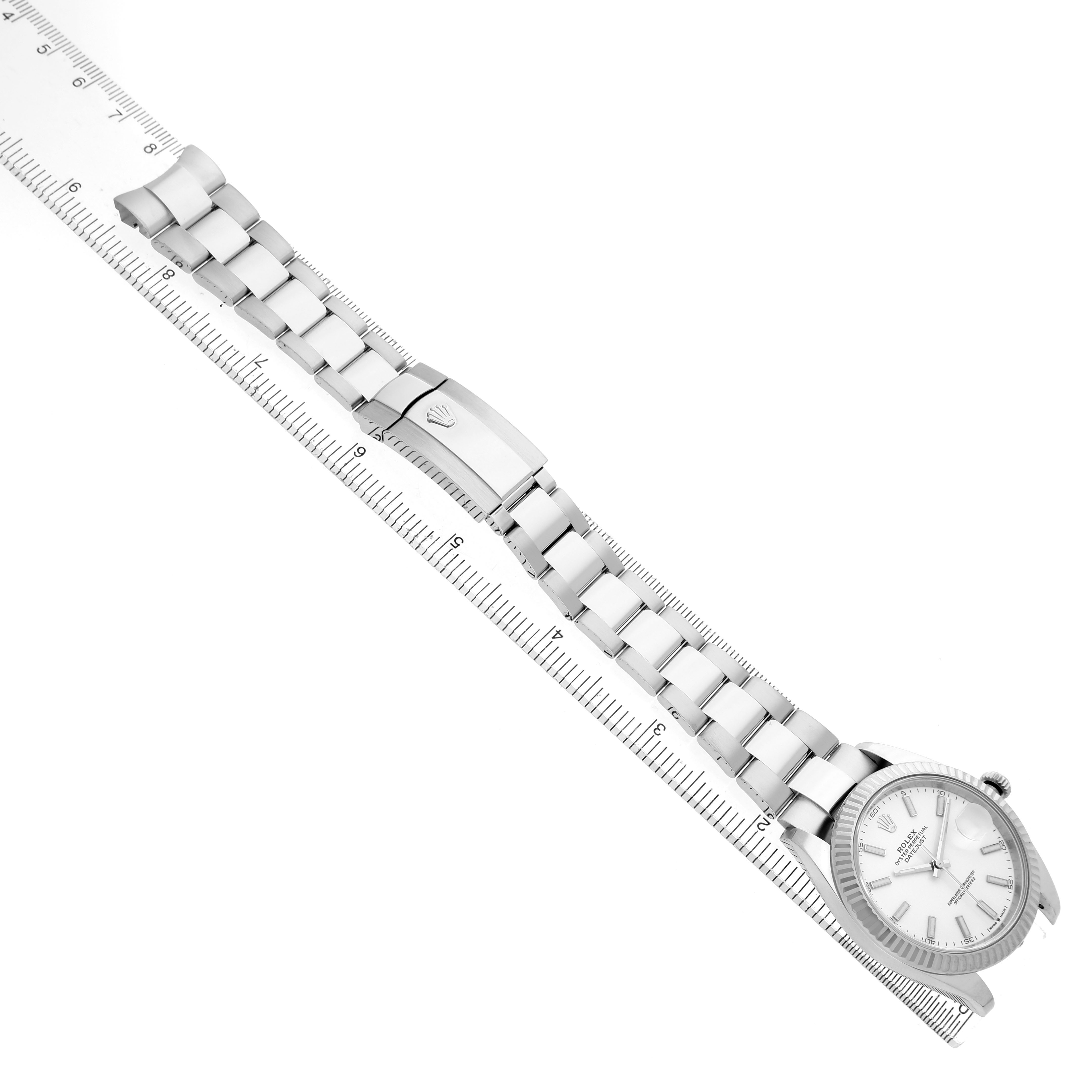 The Rolex Datejust 41 126334 Men's Stainless Steel White Dial watch is displayed at an elevated angle, showing the bracelet, clasp, and dial on a measuring ruler.