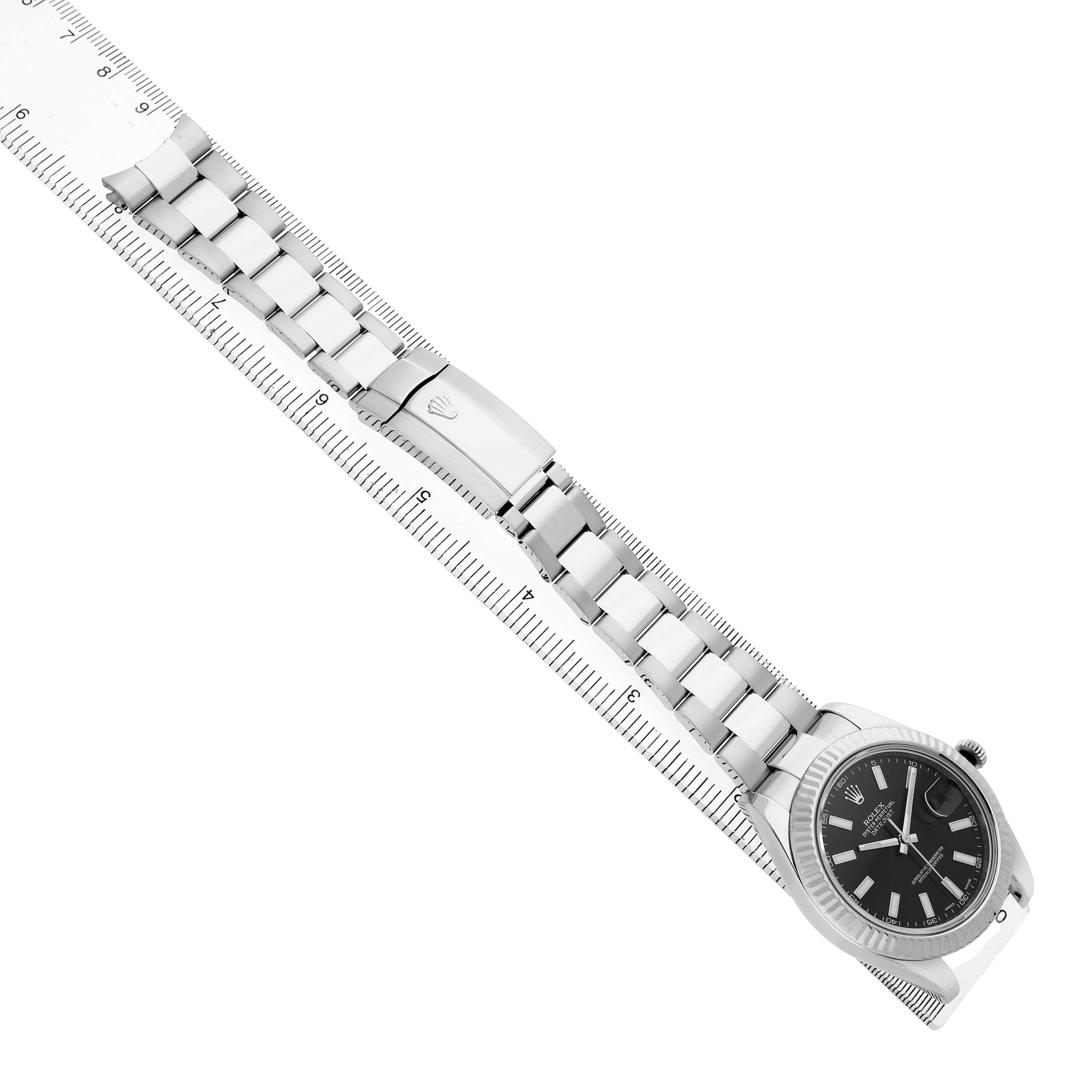 The Rolex Datejust 41 116334 Men's Stainless Steel Black Dial is shown from a top angle, highlighting the watch face, bezel, and full bracelet aligned on a ruler.