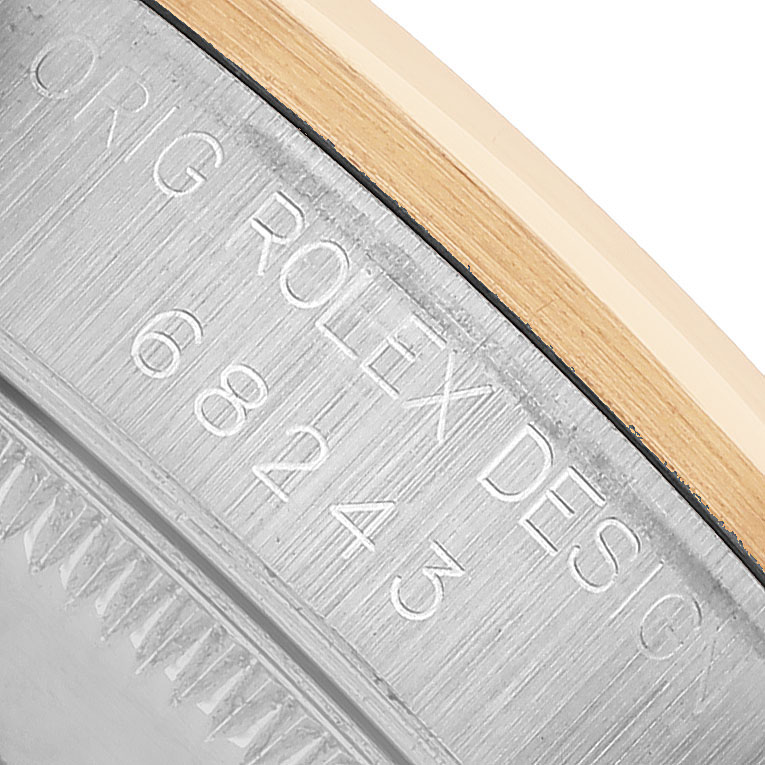 The image shows the engraved edge of a Rolex Datejust 68243 Women's Steel and Gold (two tone) Blue Dial watch case, displaying the model number and design details.