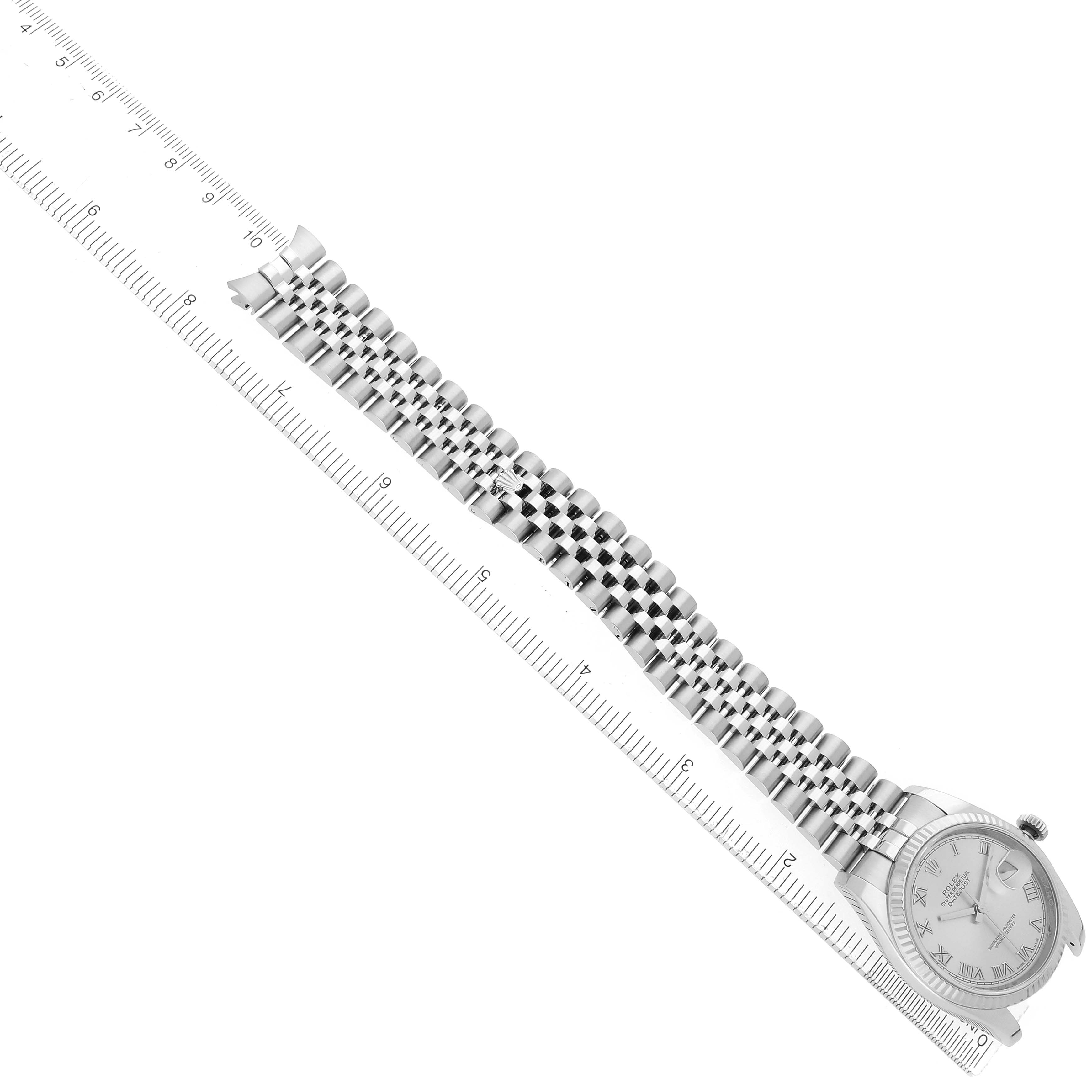 The Rolex Datejust 116234 Men
s Stainless Steel Silver Dial watch is shown diagonally, displaying its face and full Jubilee bracelet alongside a ruler for measurement.