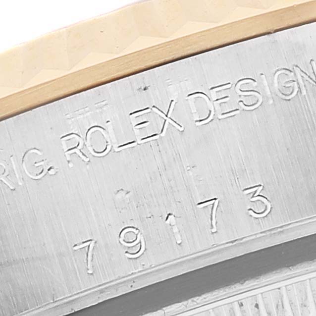 The image shows a close-up of the serial number and "ROLEX DESIGN" engraving on the case of a Rolex Datejust 79173 Women's Steel and Gold (two tone) Black Dial 79173 Women's Steel and Gold (two tone) Black Dial watch.