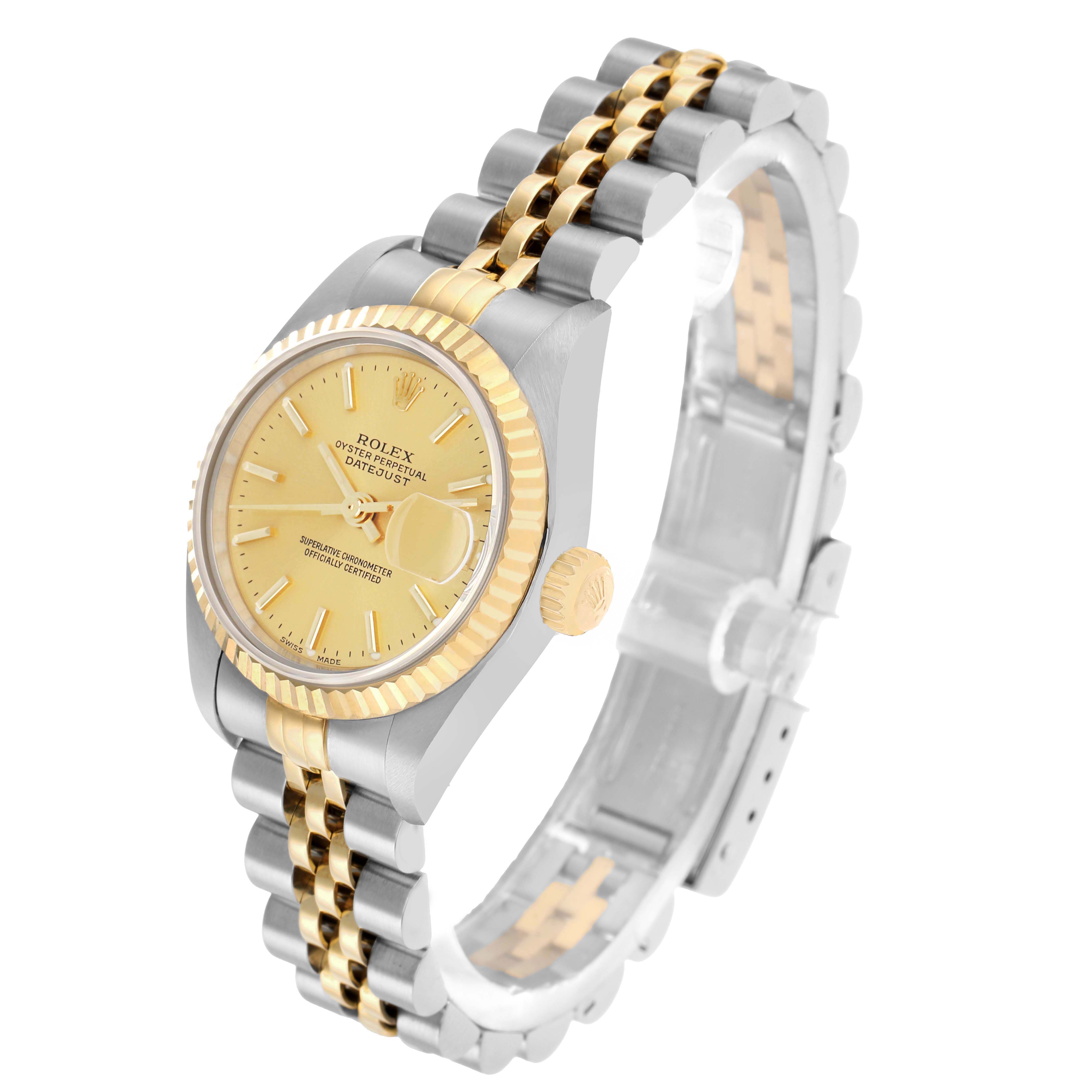 The Rolex Datejust 79173 Women
s Steel and Gold (two tone) Champagne Dial watch is shown at a slight angle, highlighting the gold dial, fluted bezel, two-tone bracelet, and side crown.
