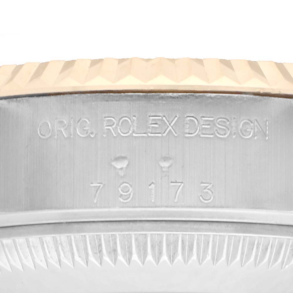 The angle shows a close-up of the case side, focusing on the model number engraving of a Rolex Datejust 79173 Women
s Steel and Gold (two tone) Champagne Dial watch.