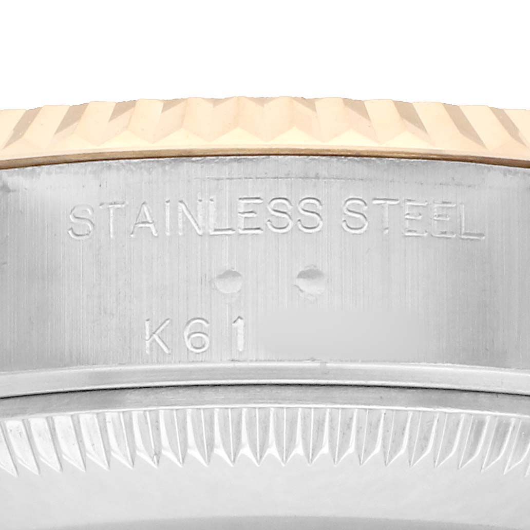 The image shows a close-up of the side of a Rolex Datejust 79173 Women
s Steel and Gold (two tone) Champagne Dial watch, highlighting the stainless steel edge and fluted bezel.