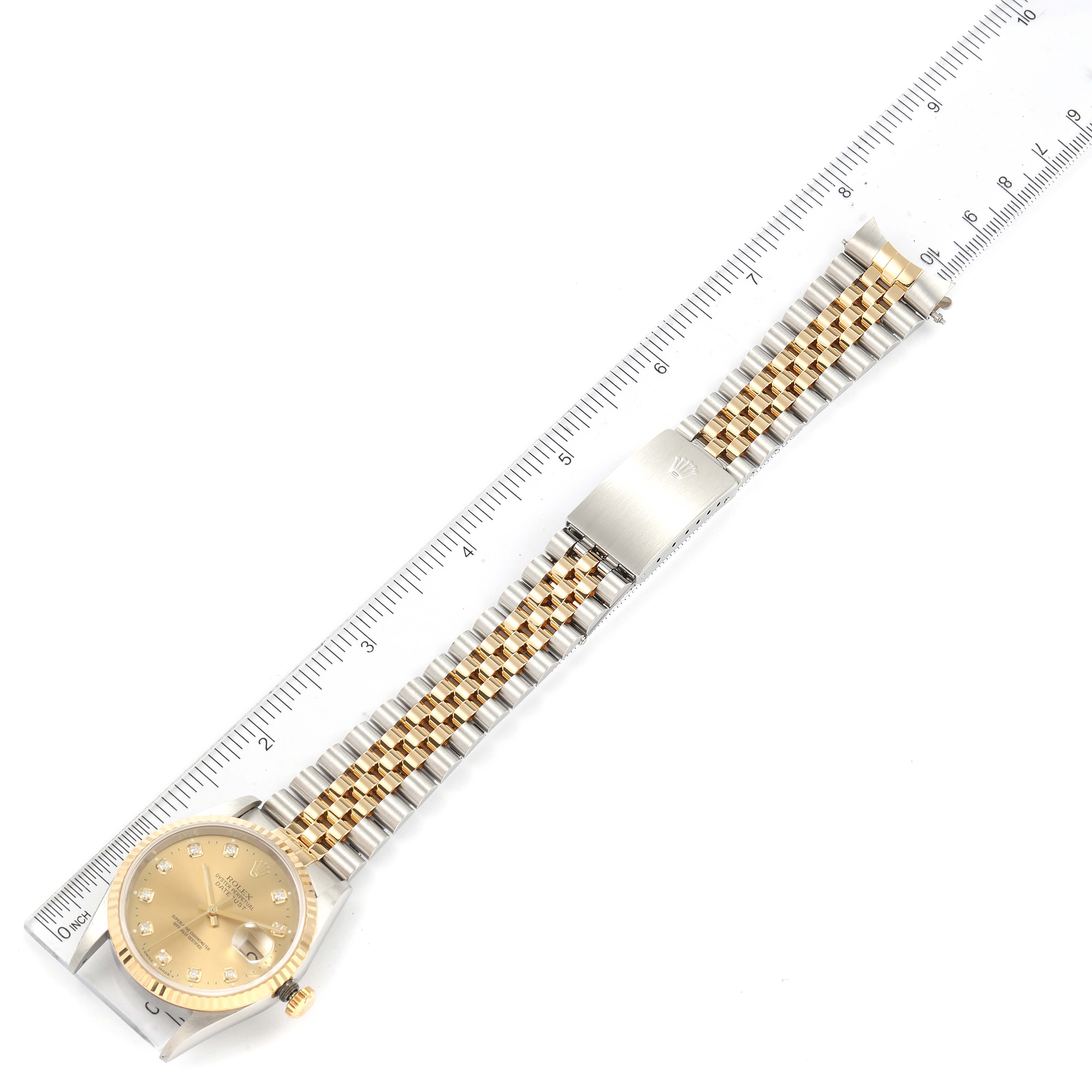 This image shows a top-down view of a Rolex Datejust 16233 Men's Steel and Gold (two tone) Champagne Dial 16233 Men's Steel and Gold (two tone) Champagne Dial watch, featuring its dial, bezel, and full bracelet next to a ruler.
