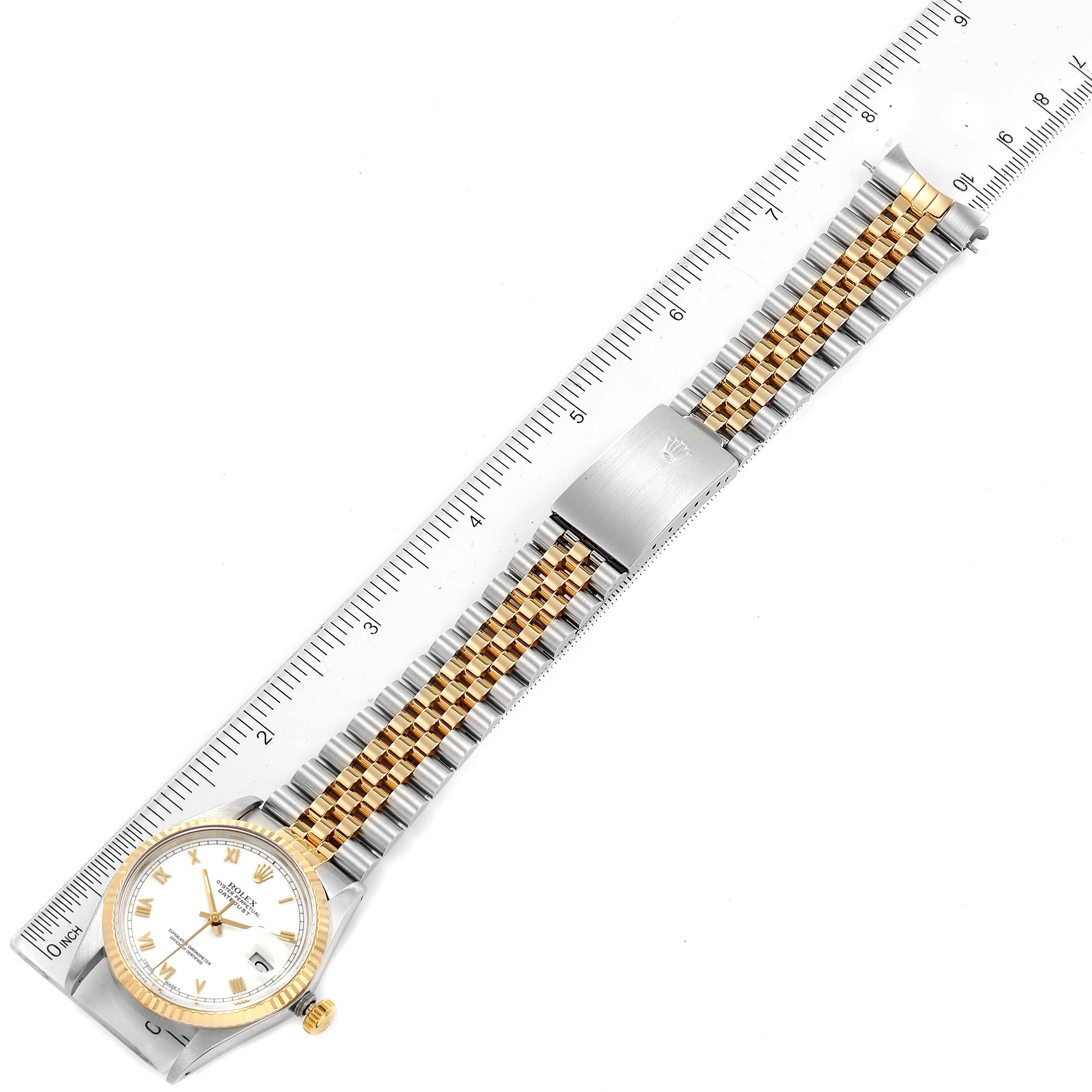 This Vintage Collection model by Rolex is shown from a top-down angle, highlighting the face, strap, and clasp next to a ruler for scale.