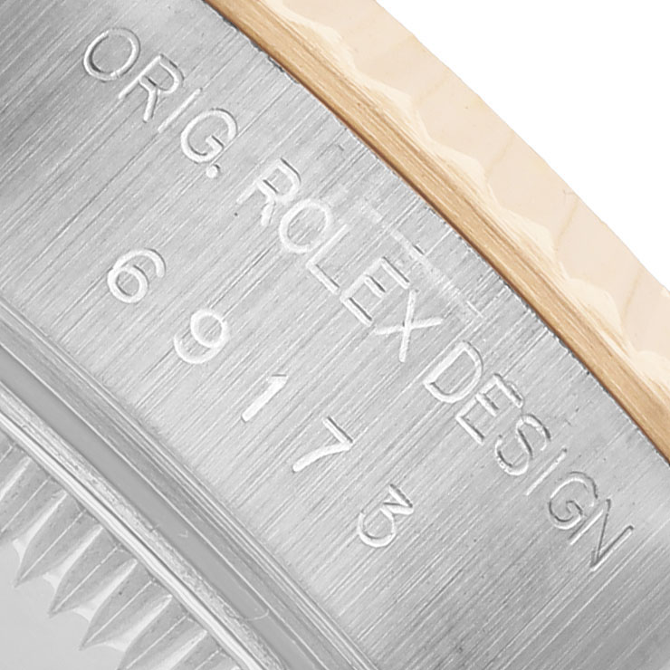 The image shows a close-up of the Rolex Datejust 69173 Women's Steel and Gold (two tone) White Dial model's case side with engraved text.