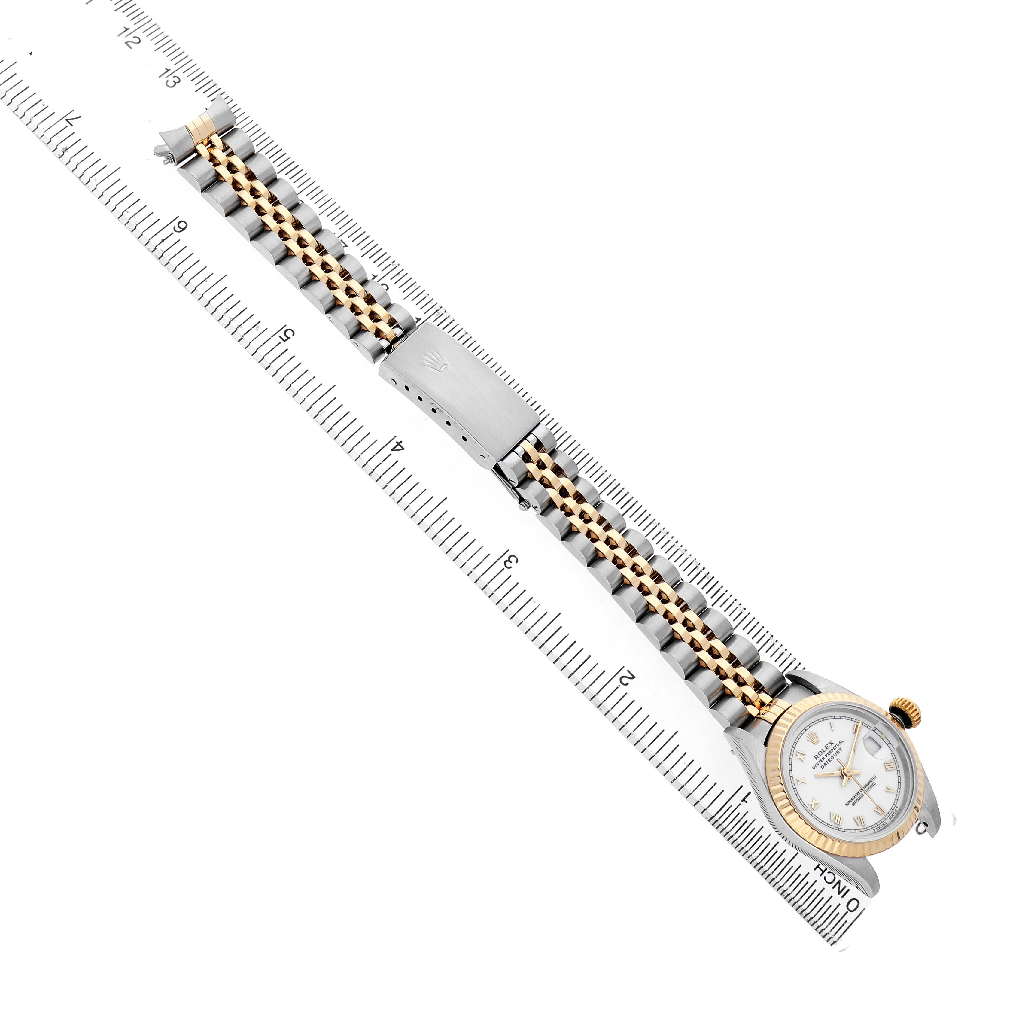 The Rolex Datejust 69173 Women's Steel and Gold (two tone) White Dial watch is shown at an angle, highlighting the face, bezel, case, bracelet, and clasp alongside a ruler.
