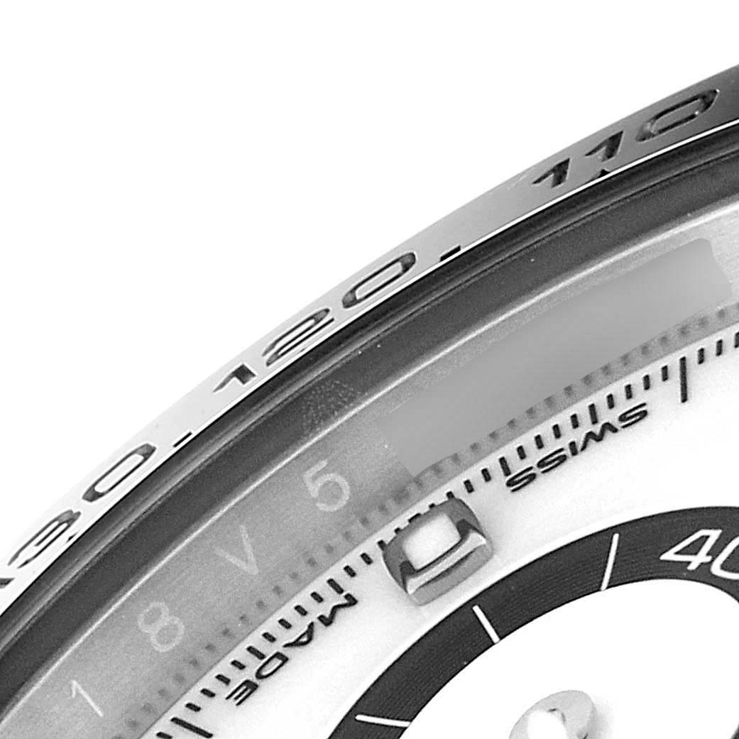 The image shows a close-up of the bezel and part of the dial of a Rolex Daytona 116500 Men's Stainless Steel White Dial 116500 Men's Stainless Steel White Dial watch.