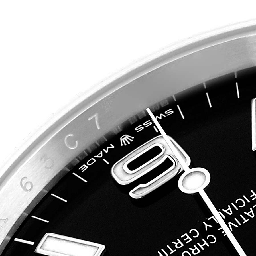 The image shows a close-up of the Rolex Explorer 124270 Men
s Stainless Steel Black Dial watch
s dial and bezel at an angle, highlighting the numbers and markings.
