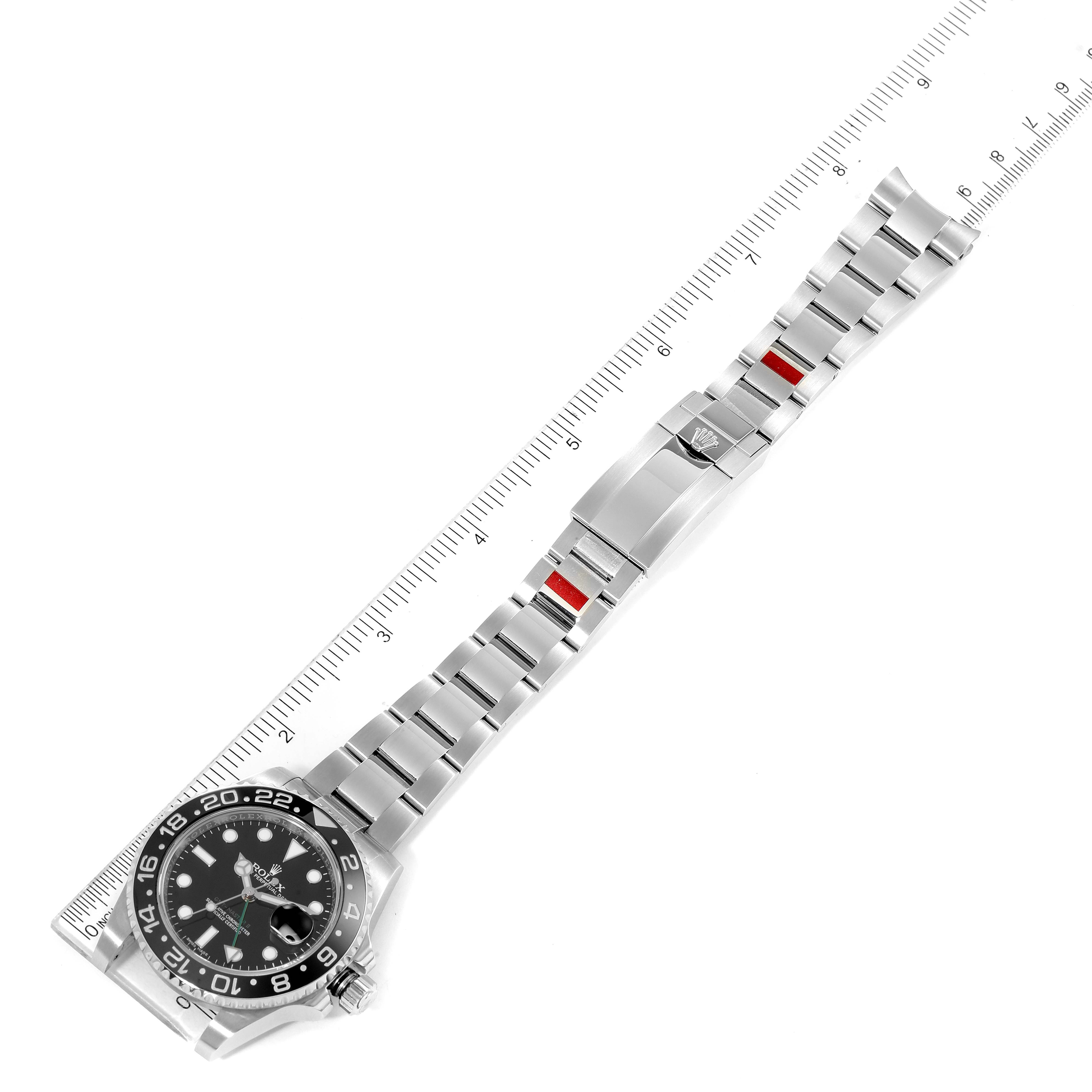The Rolex GMT-Master 116710 Men
s Stainless Steel Black Dial 116710 Men
s Stainless Steel Black Dial watch is shown laid flat and measured with a ruler, displaying the entire band and face.