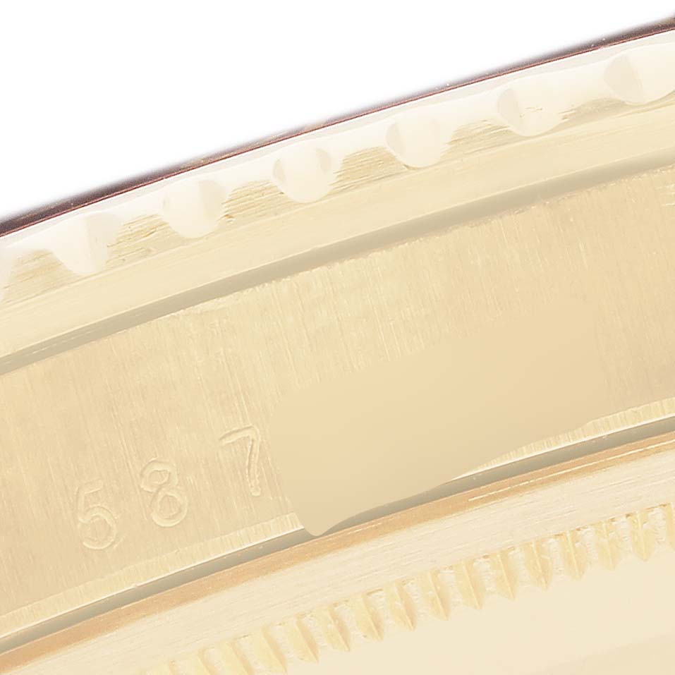 The image shows a close-up of the bezel and case edge details of a Rolex GMT-Master 1675 Men
s Yellow Gold Brown Dial watch, highlighting the engravings and edges.