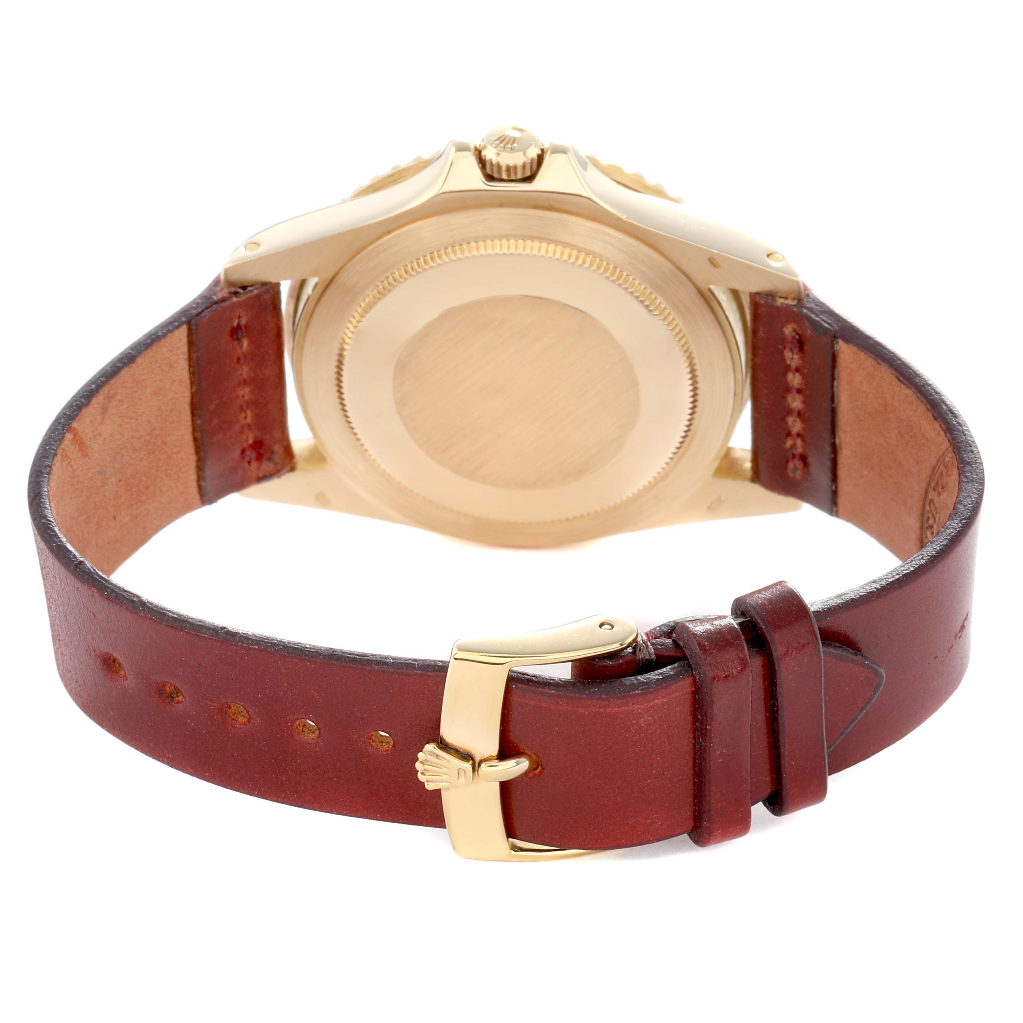 The image shows the back view of a Rolex GMT-Master 1675 Men
s Yellow Gold Brown Dial watch, featuring its caseback and leather strap with a gold buckle.