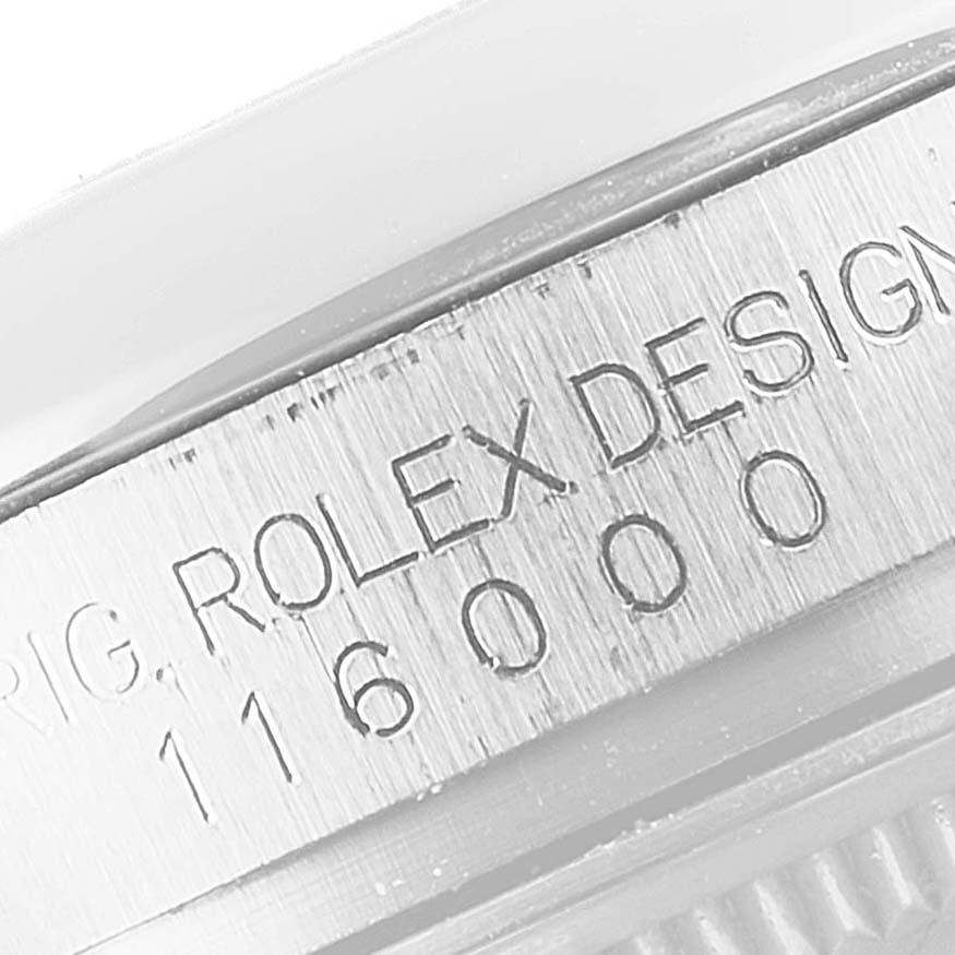 The image shows a close-up of the side of a Rolex Oyster Perpetual 116000 Men's Stainless Steel Silver Dial 116000 Men's Stainless Steel Silver Dial watch's case with "ROLEX DESIGN 116000" engraved.