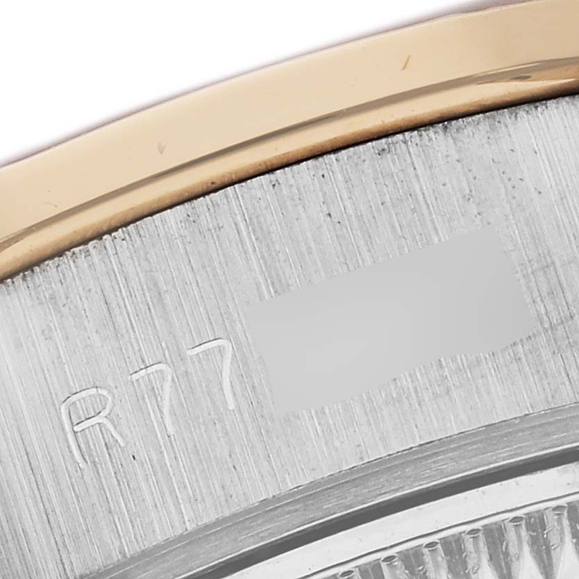 The image shows a close-up of the side edge and part of the bezel of a Rolex President 69149 Women's White Gold Champagne Dial watch, highlighting engraved details.