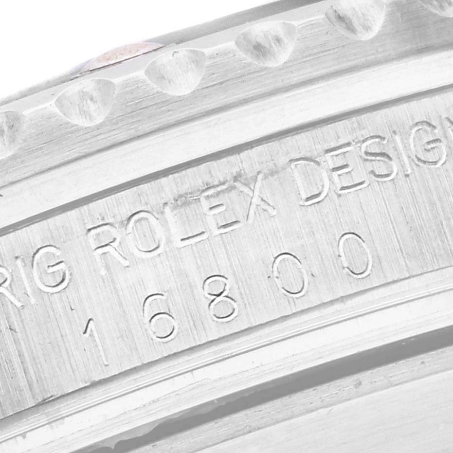 The image shows a close-up of the engraved bezel and serial number on a Rolex Vintage Collection 16800 Men's Stainless Steel Black Dial 16800 Men's Stainless Steel Black Dial model.