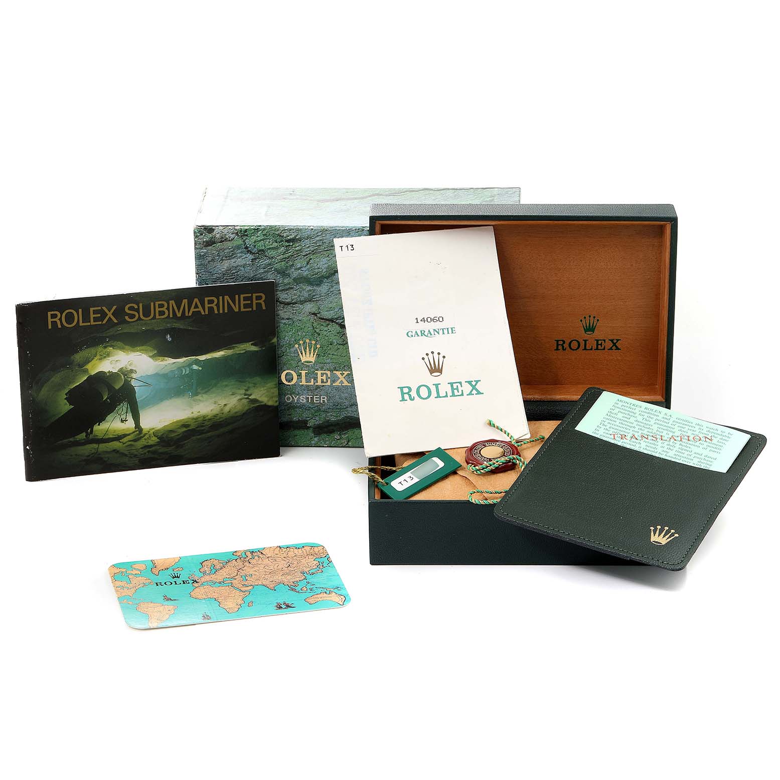 The image shows accessories for a Rolex Submariner 14060 Men
s Stainless Steel Black Dial 14060 Men
s Stainless Steel Black Dial watch, including its box, guarantee, booklet, tag, and wallet.