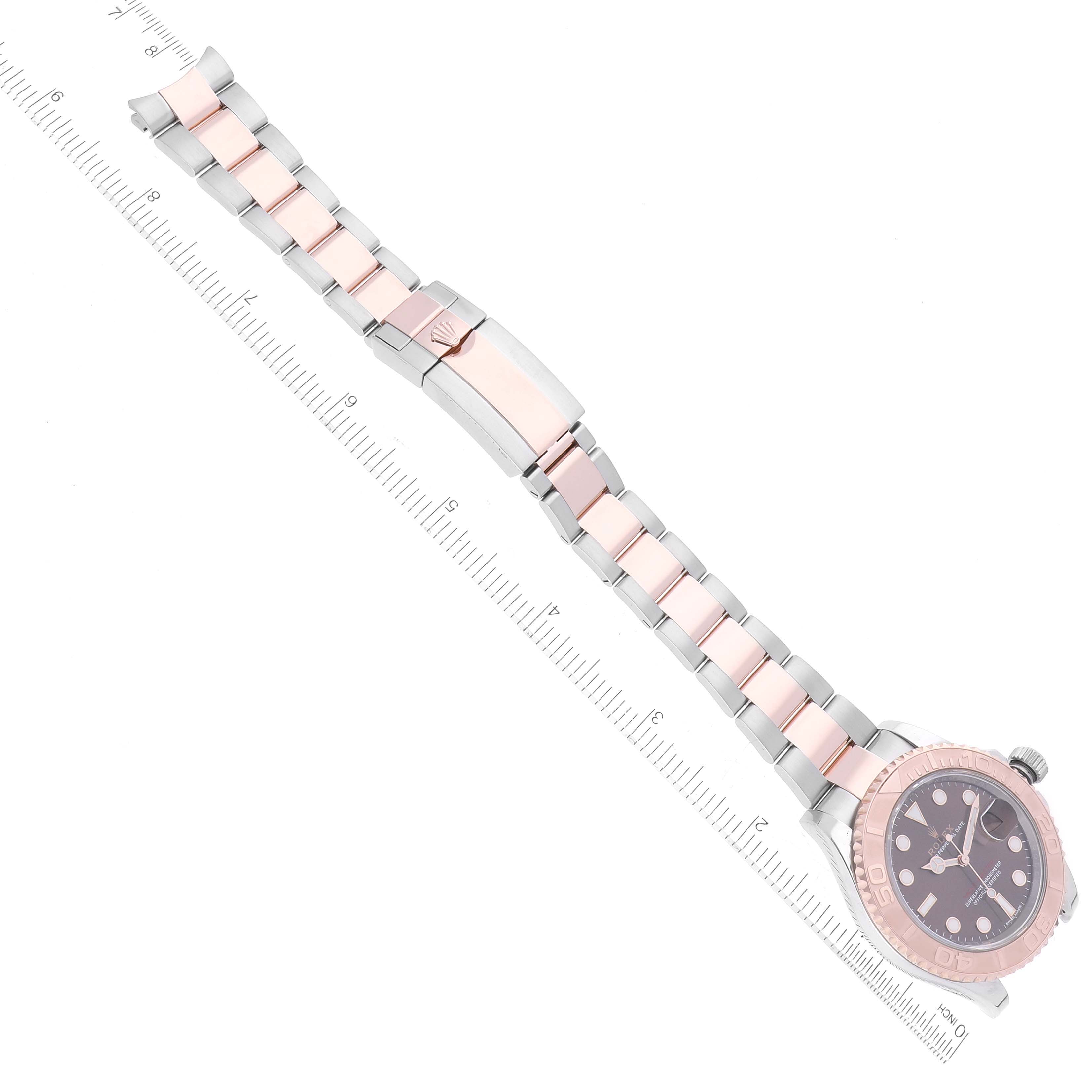 This image shows a top-down view of the Rolex Yacht-Master 116621 Men's Steel and Gold (two tone) Brown Dial 116621 Men's Steel and Gold (two tone) Brown Dial watch, highlighting its face and bracelet with an attached ruler.