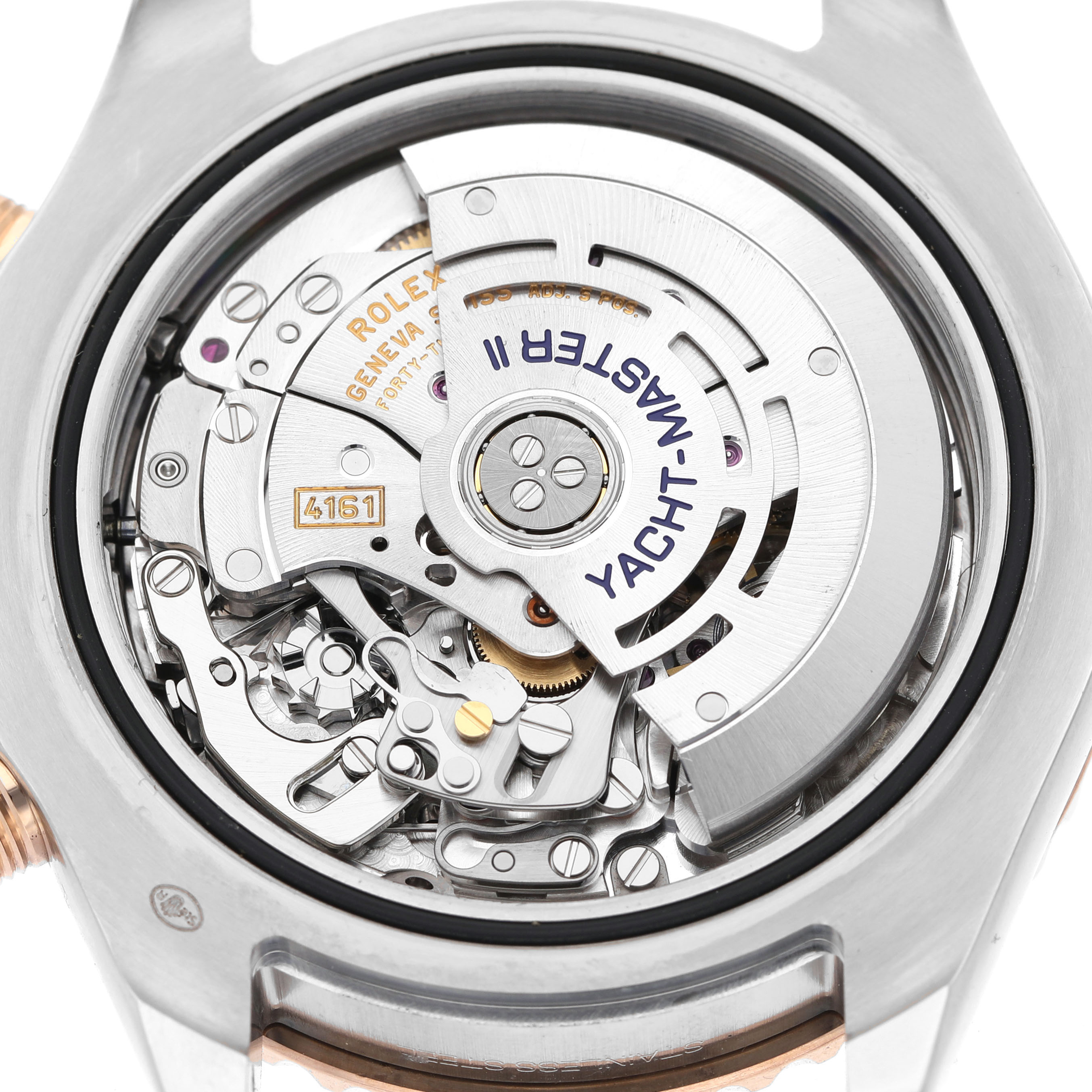 The image shows a close-up of the Rolex Yacht-Master 116681 Men's Steel and Gold (two tone) White Dial model's movement from the back, featuring the rotor and intricate gears.