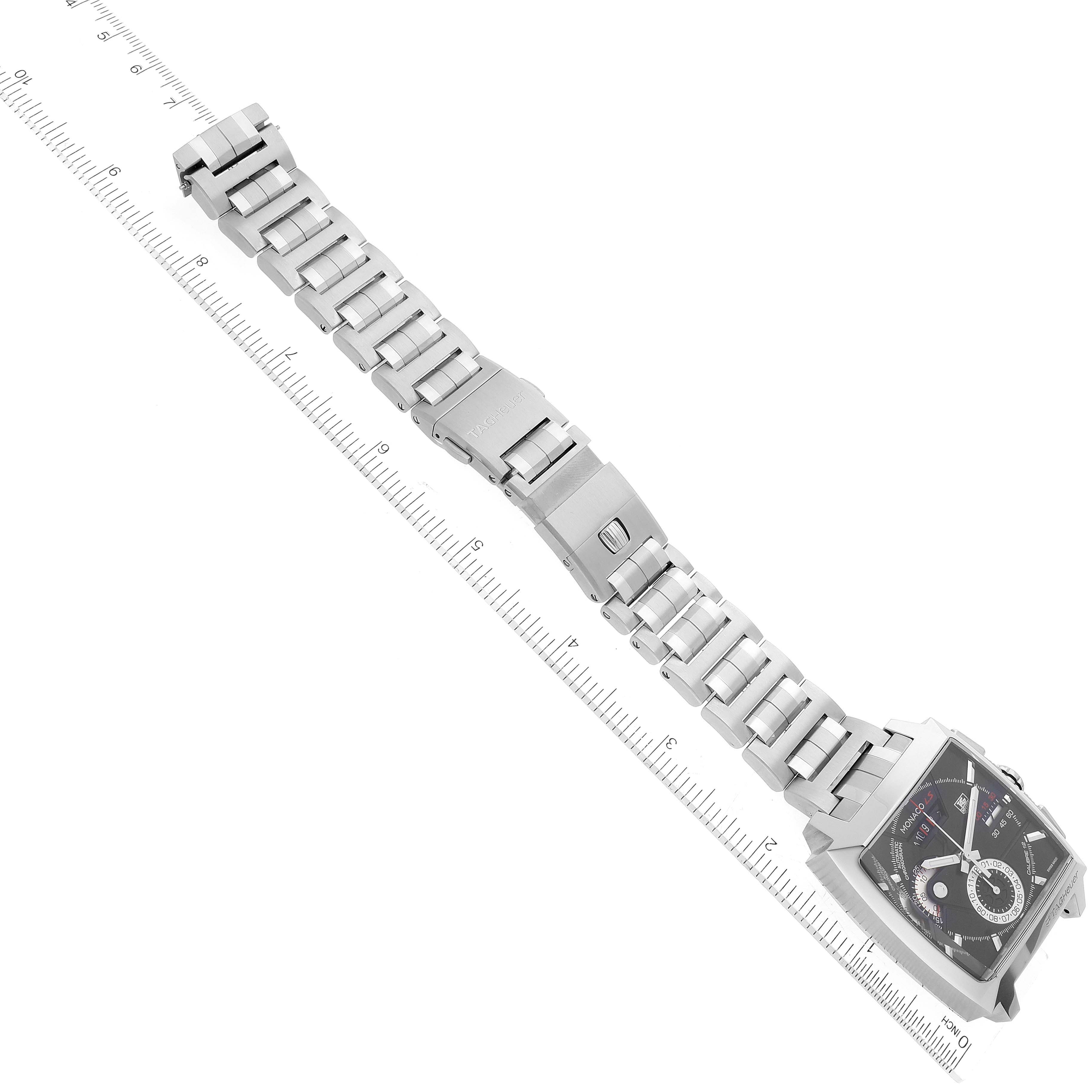 The image shows a top view of a Tag Heuer Monaco CAL2110.BA0781 Men's Stainless Steel Black Dial CAL2110.BA0781 Men's Stainless Steel Black Dial watch with its stainless steel bracelet fully extended and a ruler for scale.