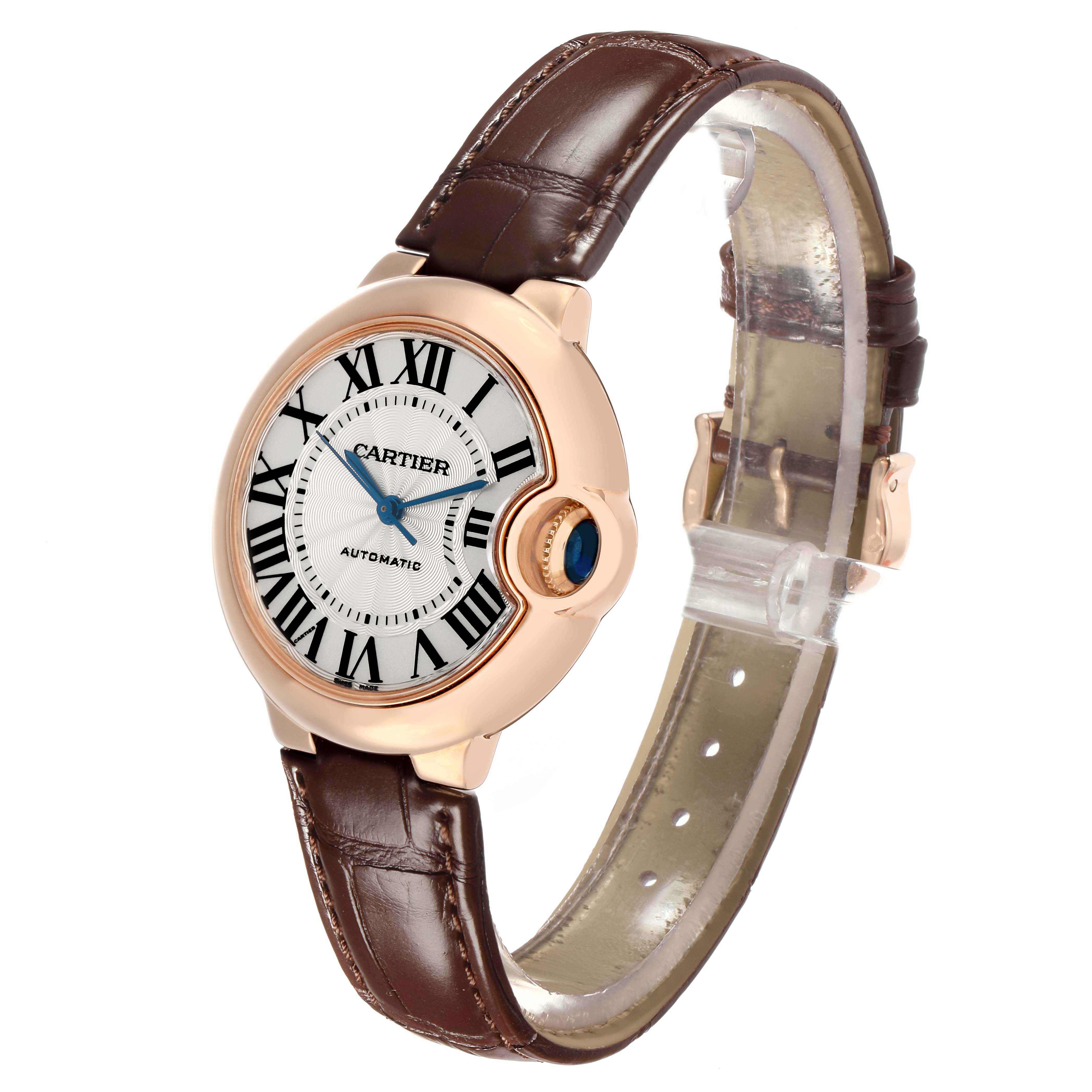 The Cartier Ballon Bleu W6920097 Women's Rose Gold Silver Dial watch is shown at an angled view, highlighting the face, crown, and leather strap.